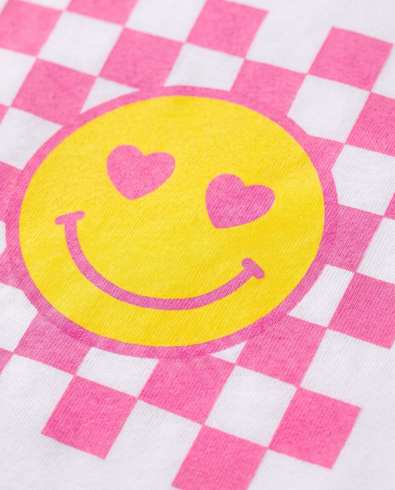 Yellow smiley face with pink hearts on a pink and white checkered background