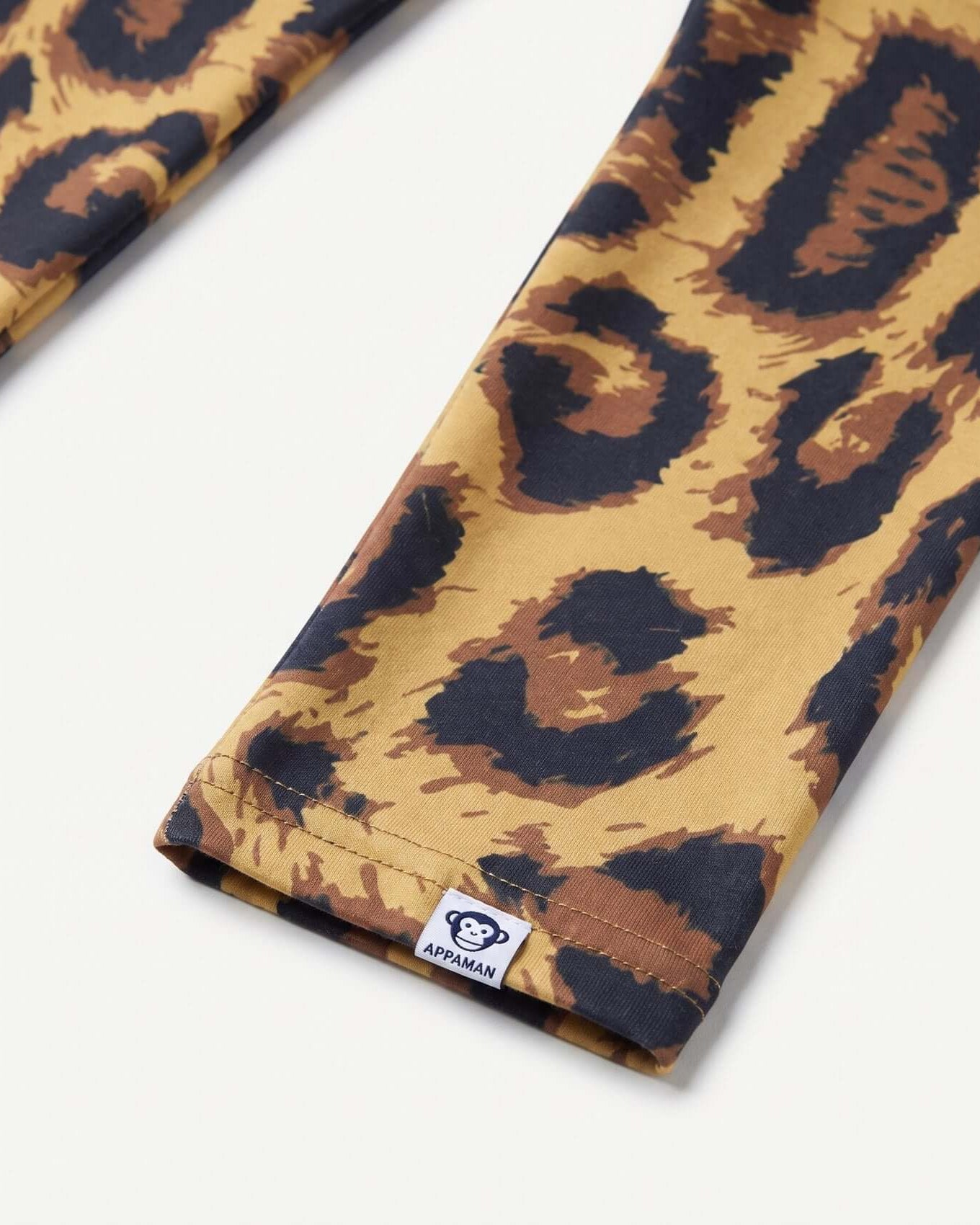 Leopard print fabric with a visible brand label on a white background