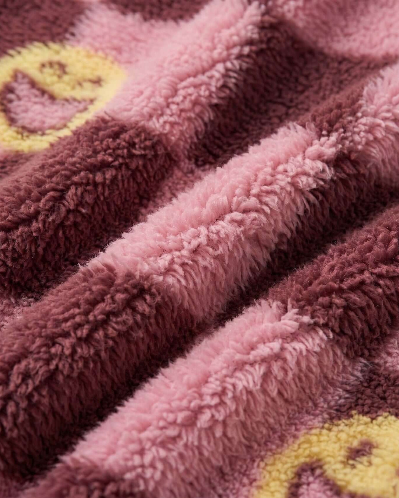 Close-up of a plush pink blanket with yellow patterns