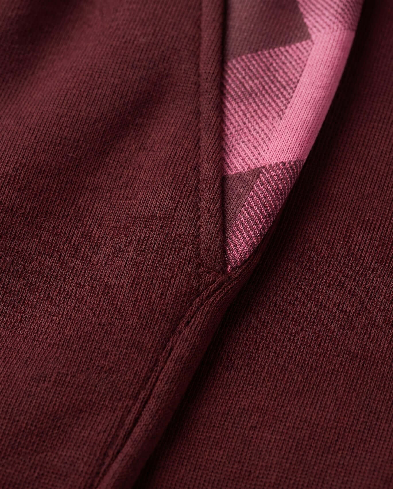 Close-up of a maroon fabric with a geometric patterned edge