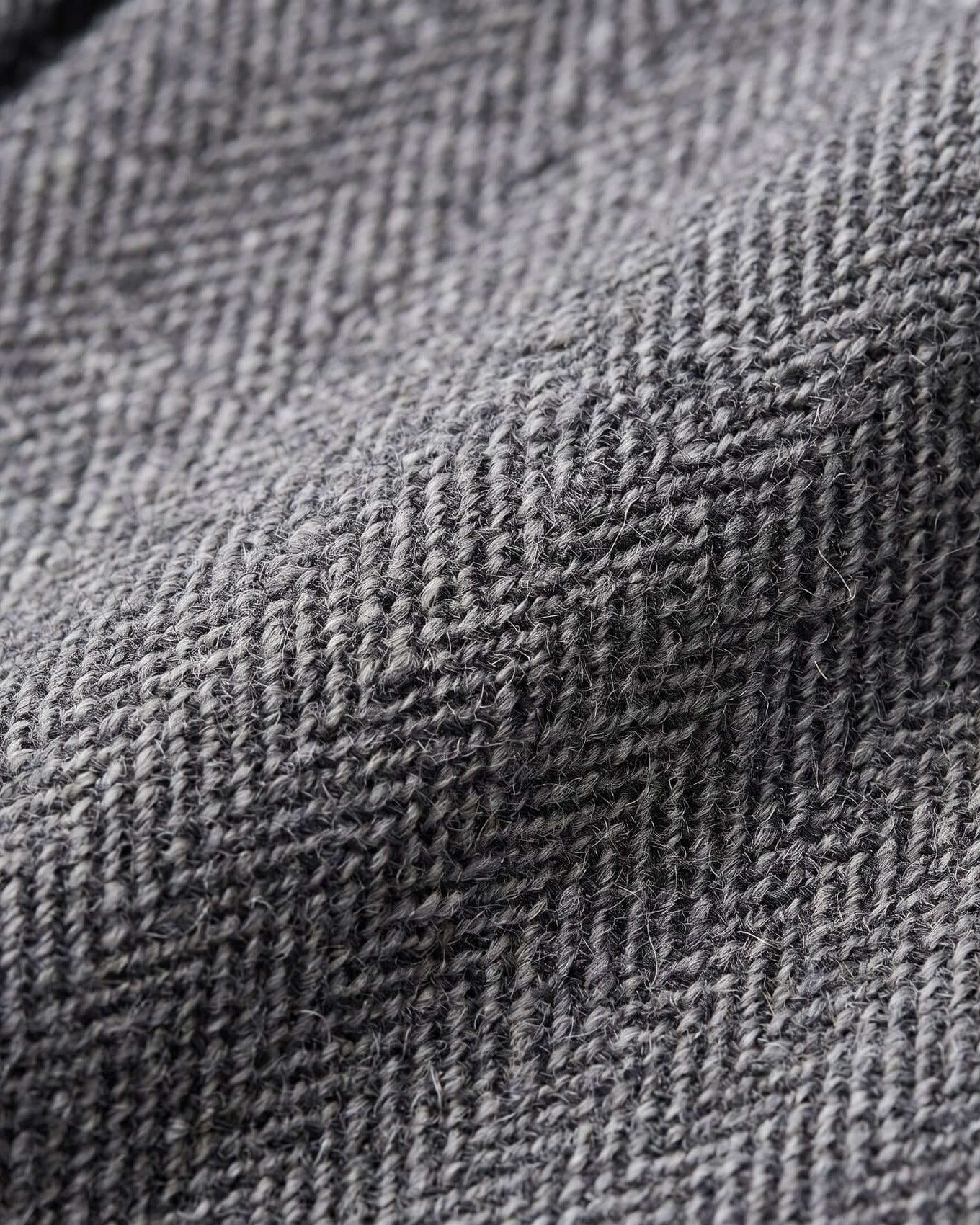 Close-up of gray textured fabric with a herringbone pattern