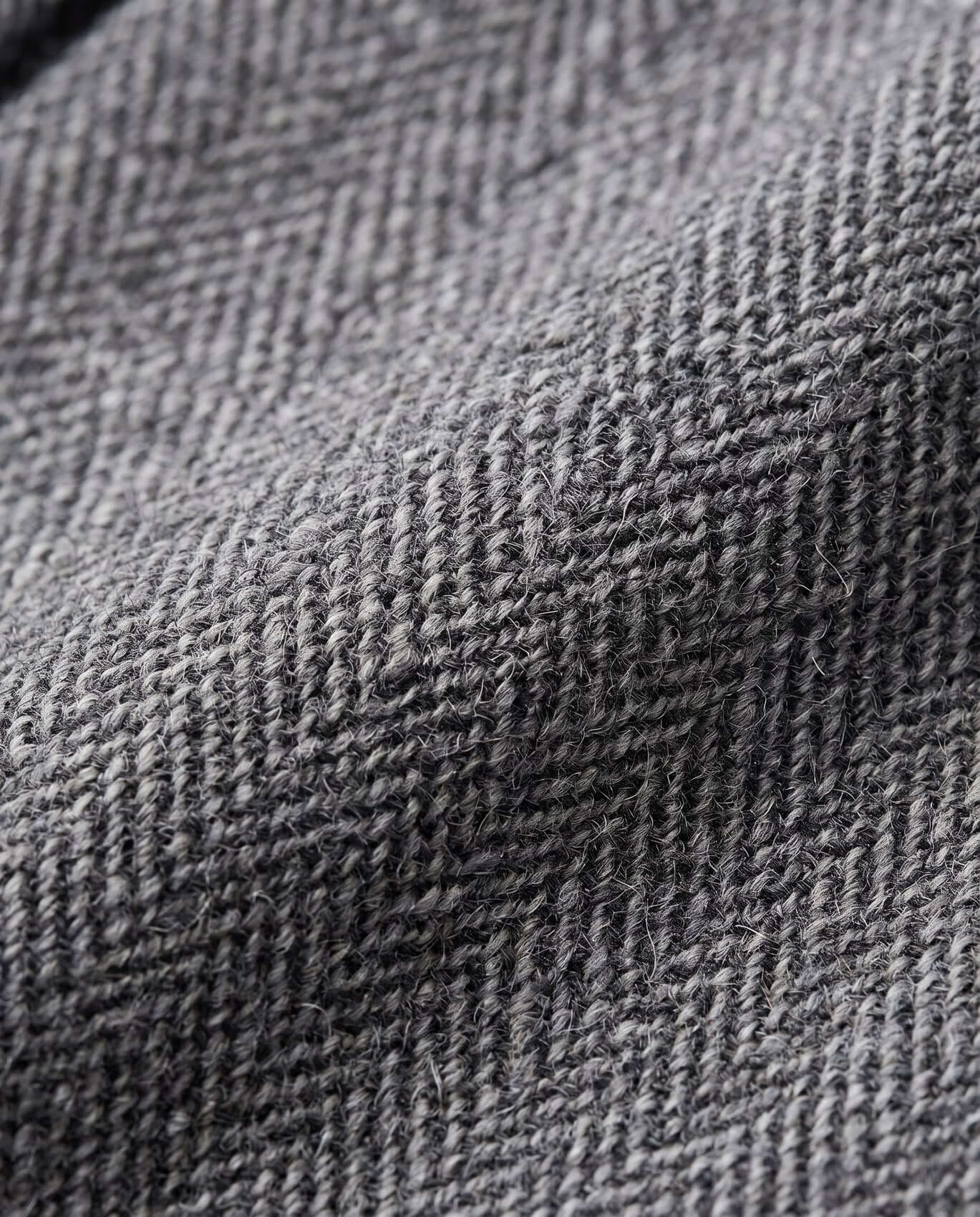Close-up of gray textured fabric with a herringbone pattern