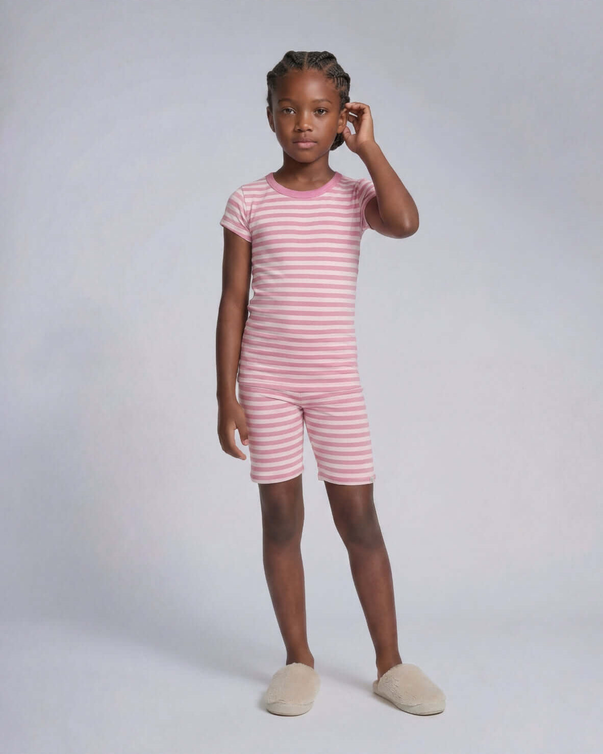 Child wearing a pink and white striped outfit on a plain background
