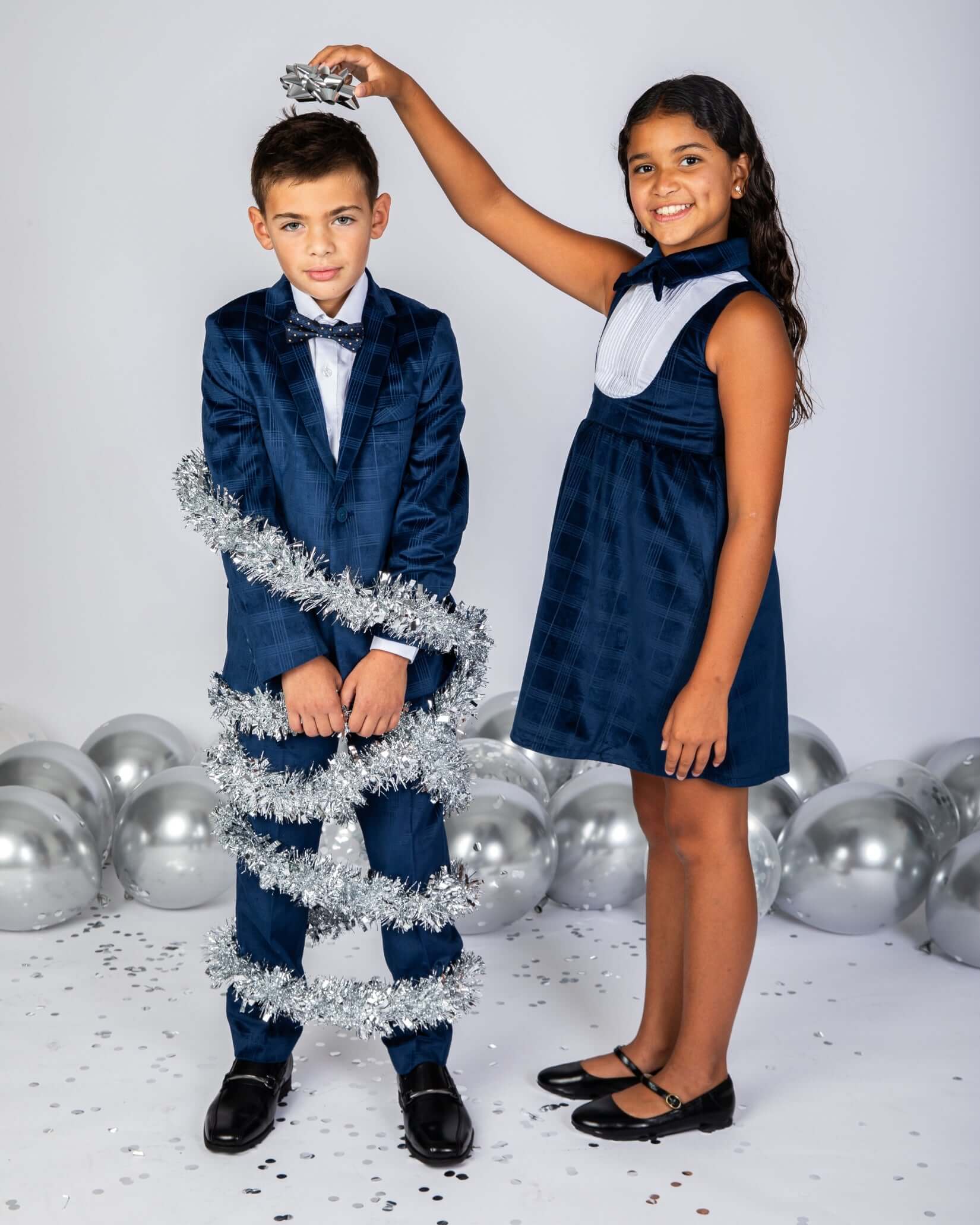 Children in a Blue Velvet Suit Blazer and matching holiday attire with festive decorations.