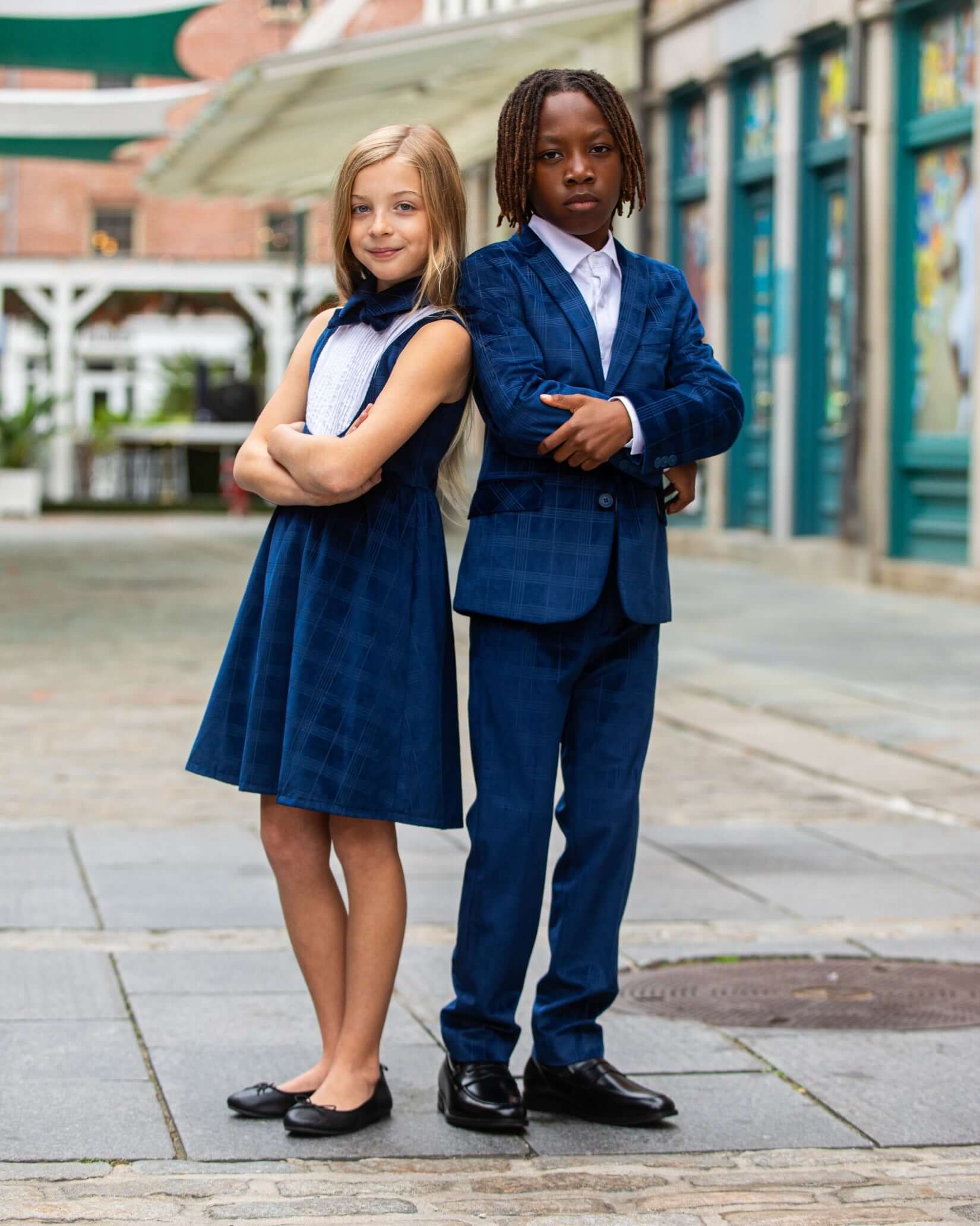 Children modeling Blue Velvet Suit Blazer and a matching blue dress in a stylish outdoor setting.