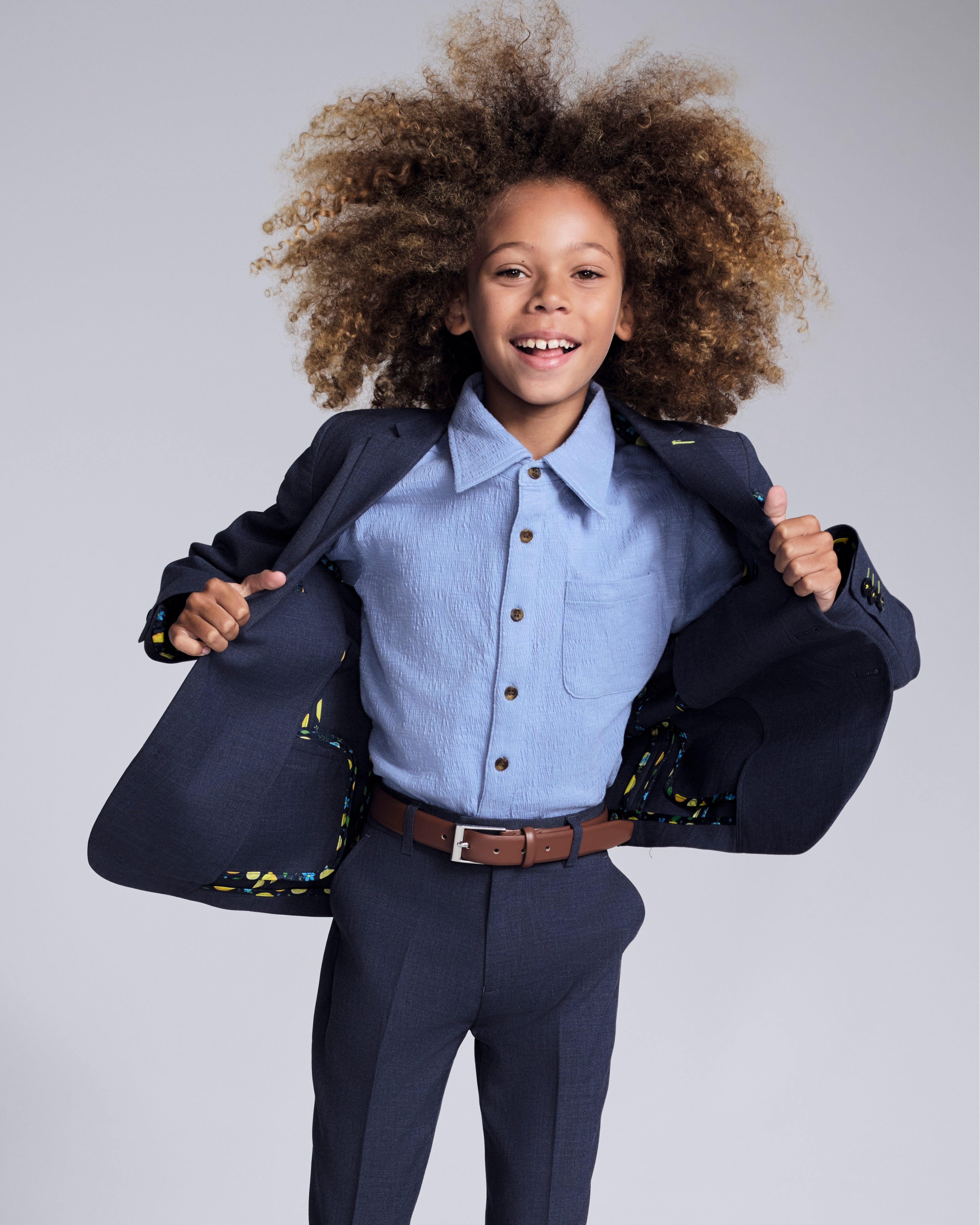 Young child wearing a Glacier Lake Beach Shirt under a stylish blazer, showcasing summer fashion for kids.