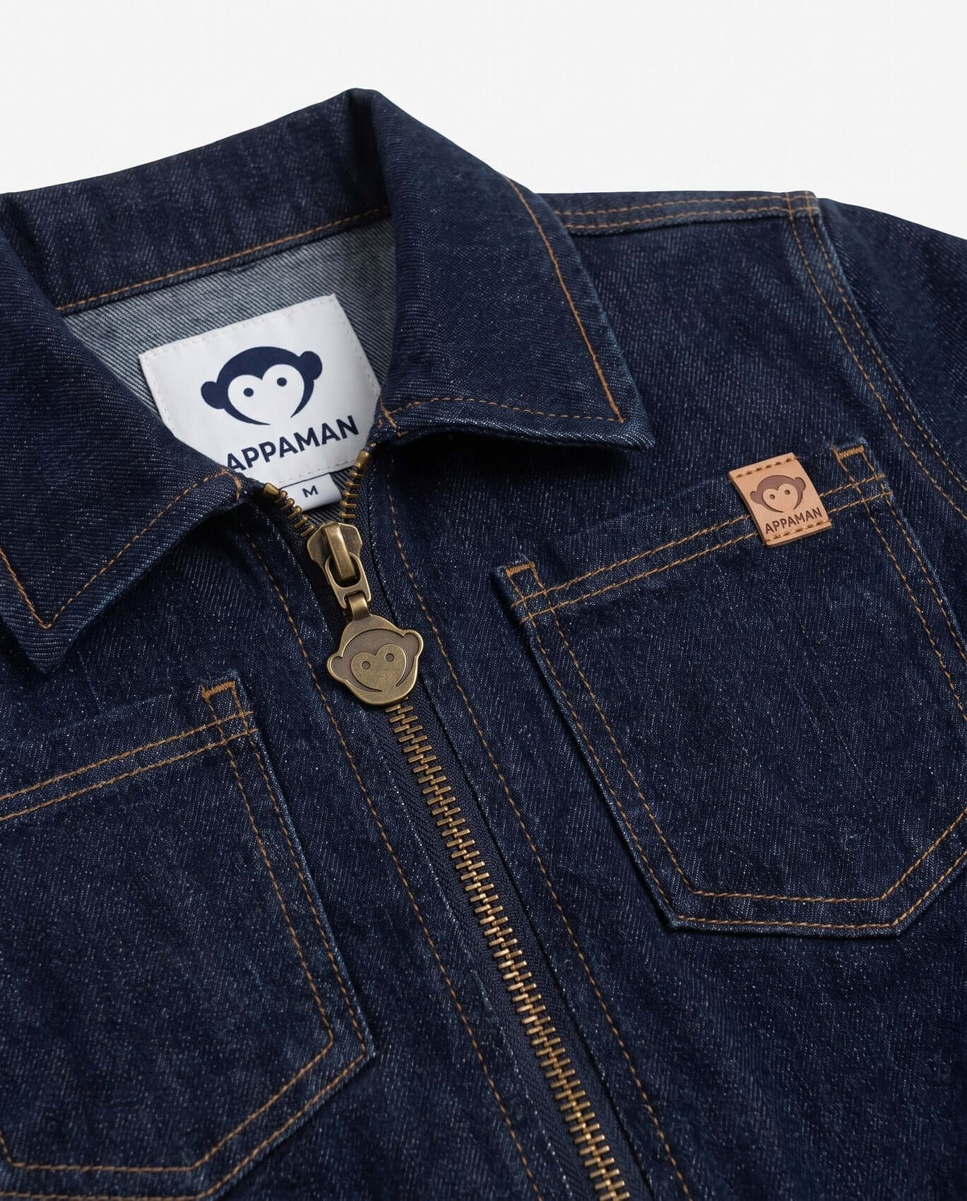 Close-up of a blue denim jacket with Appaman label and logo.