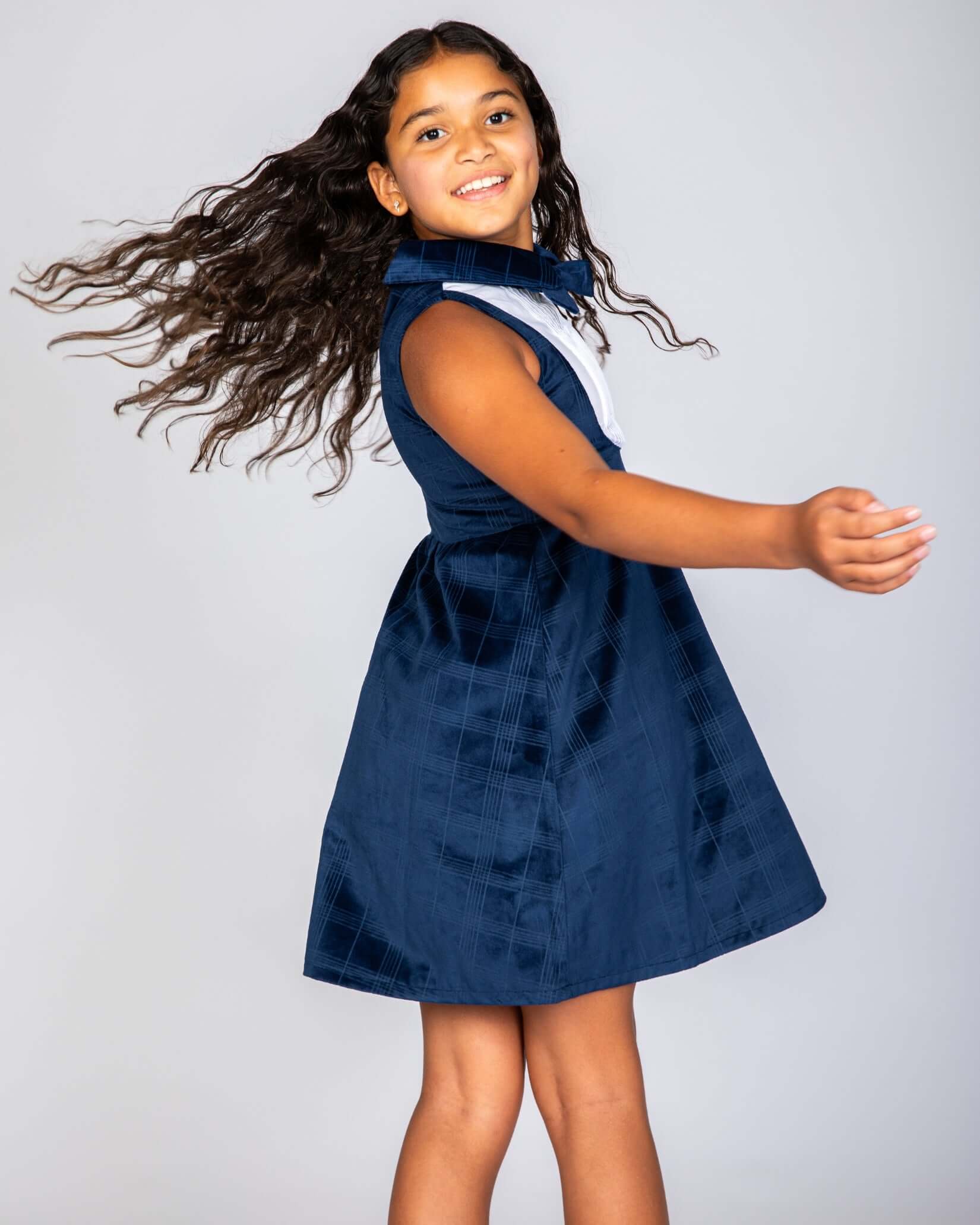 Girl wearing a Blue Velvet Windows Tuxedo Dress, showcasing the stylish design and flowing hair.