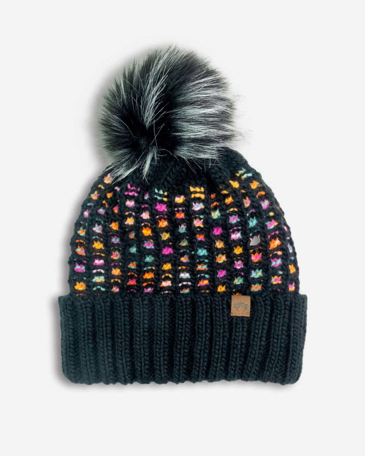 Black & Pink Kathleen Beanie with a colorful rainbow pattern and fluffy pom-pom for winter warmth and style.