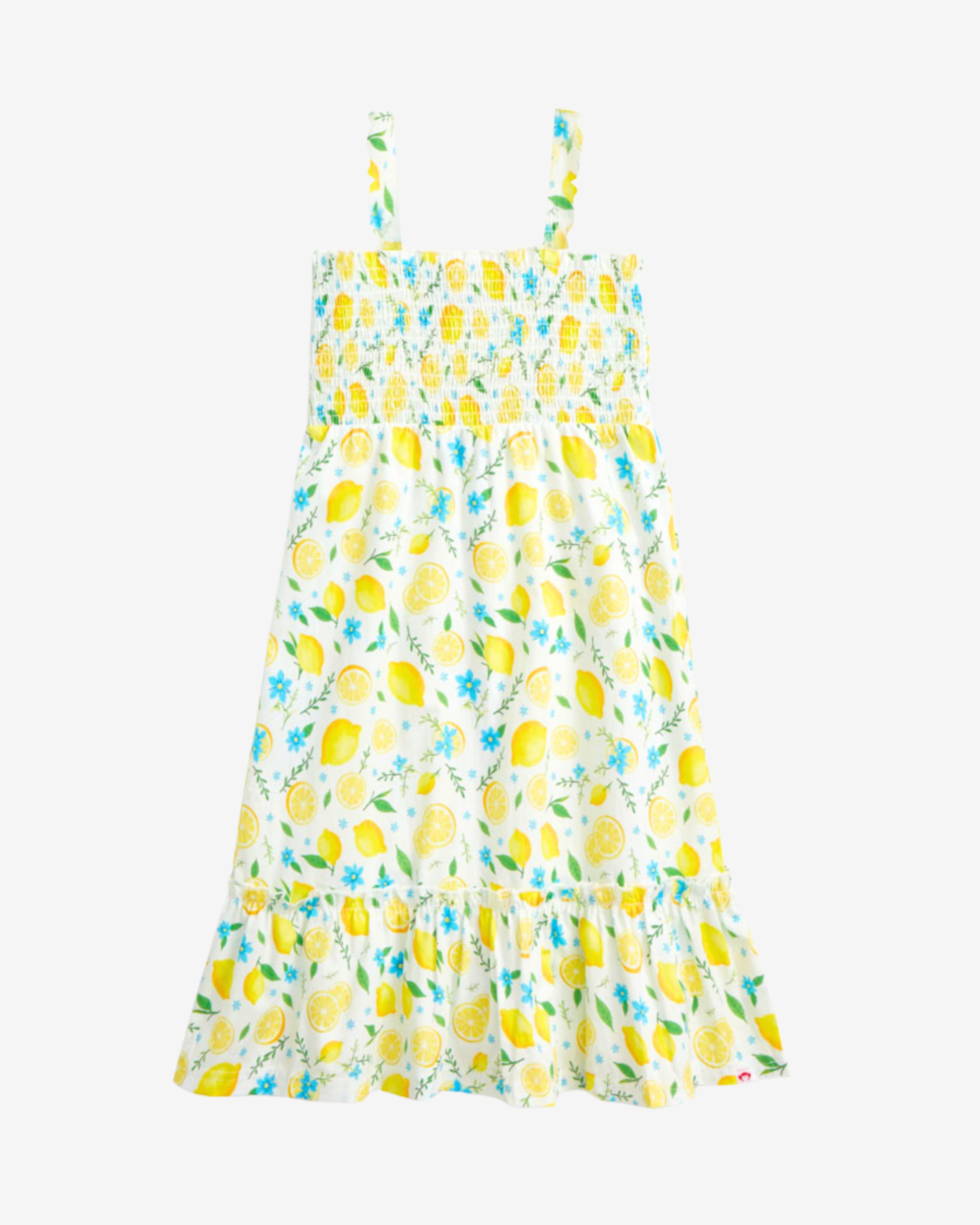 Lemon Zest Madison Dress featuring a cheerful lemon print, ruffle hem, and lightweight cotton design for sunny outings.