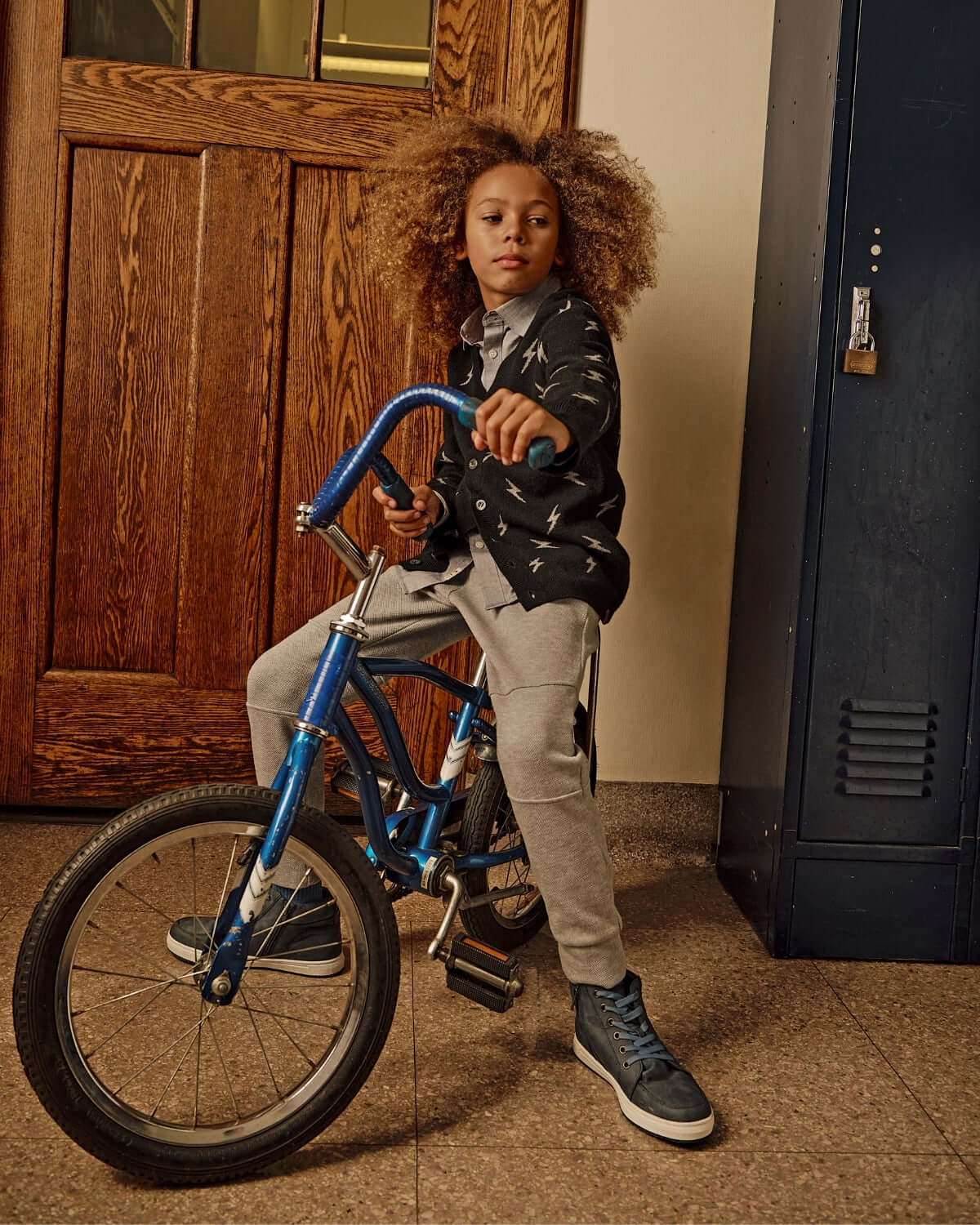 Child in Novelty Grey Heather Sideline Sweatpants riding a blue bicycle, showcasing style and comfort.