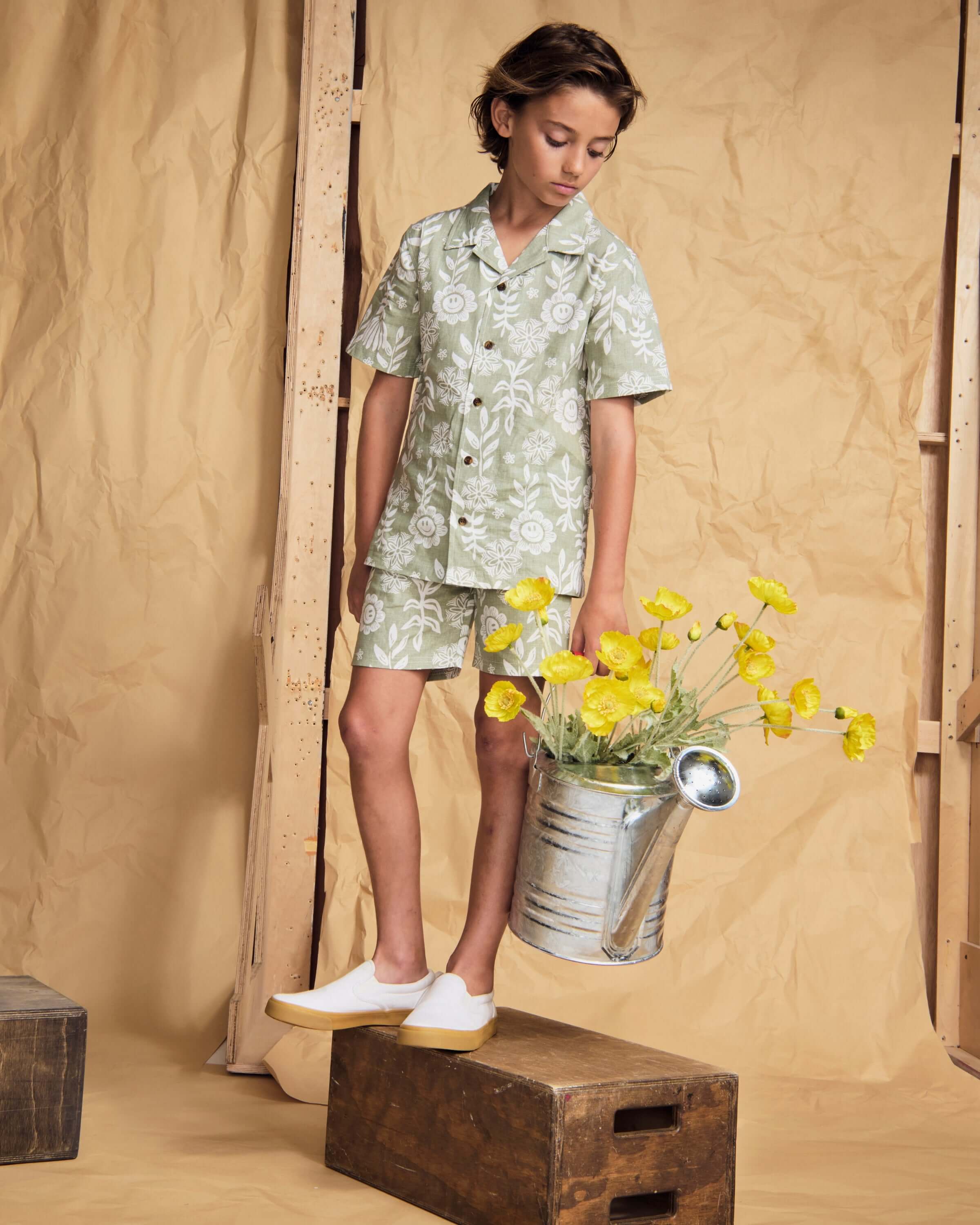 Child model wearing Linen Sage Sunflower Resort Set, featuring a breathable linen blend, shorts, and buttoned shirt.