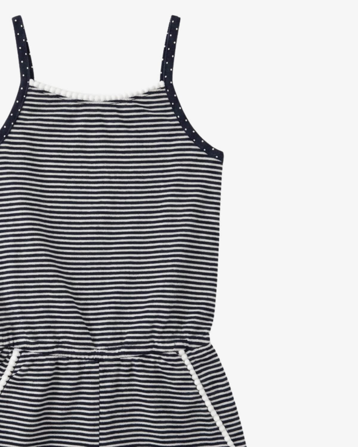 Black and white striped dress with polka dot straps on a light gray background