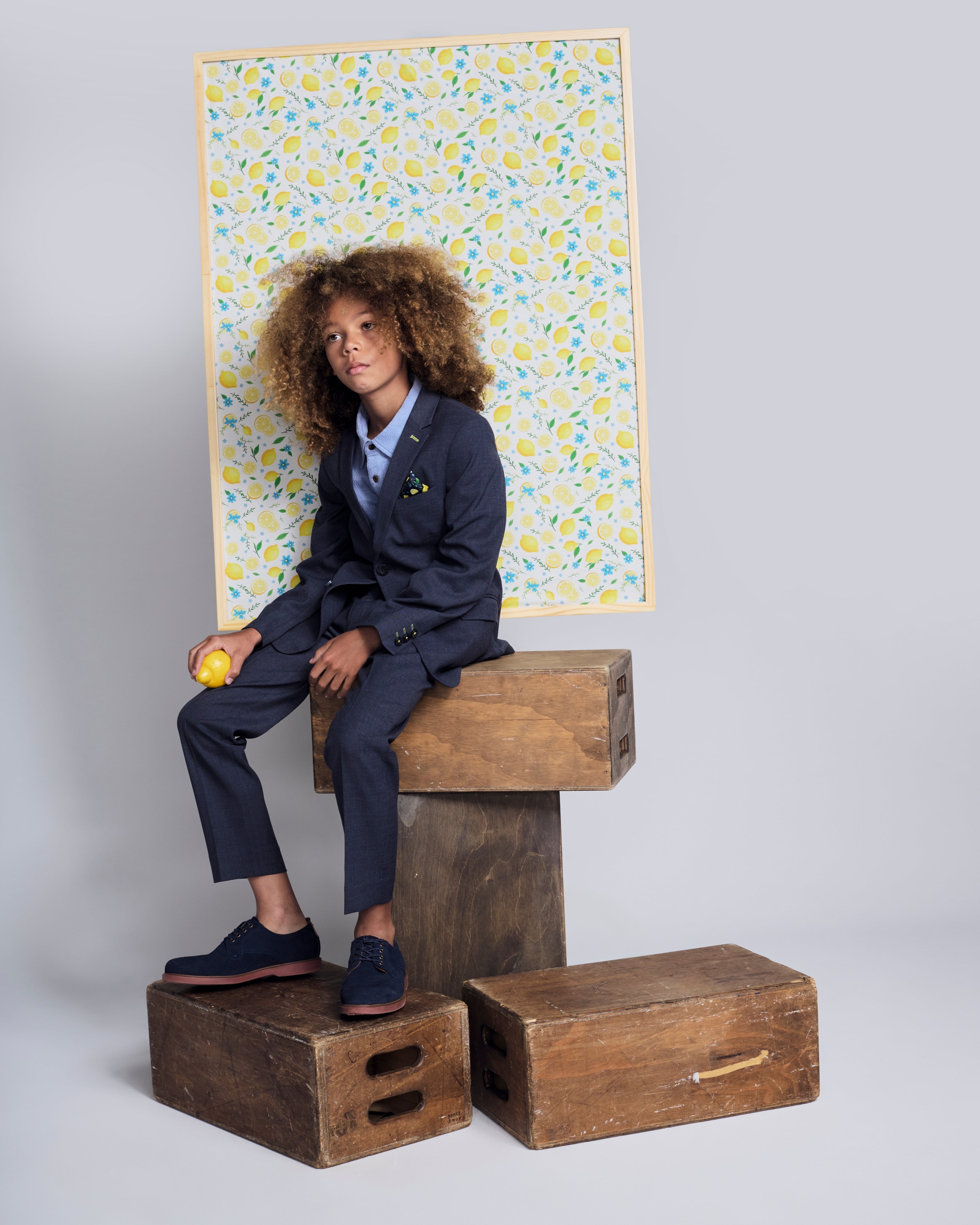 Boy modeling the Peacoat Stretchy Mod Suit, featuring a tailored jacket and stylish accessories, against a vibrant background.