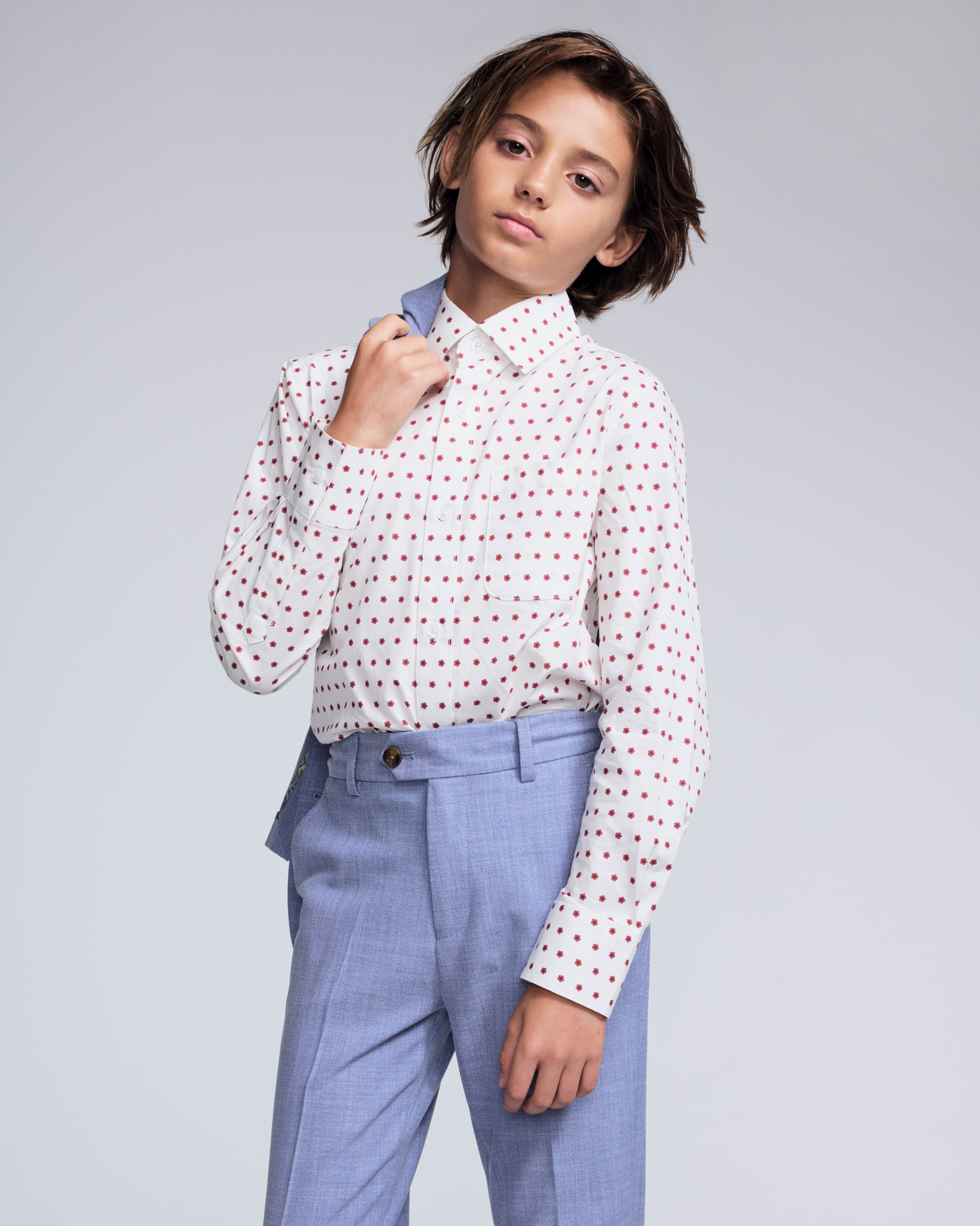 Boy wearing the Red Hibiscus Standard Button Down Shirt with stylish trousers, showcasing summer fashion.