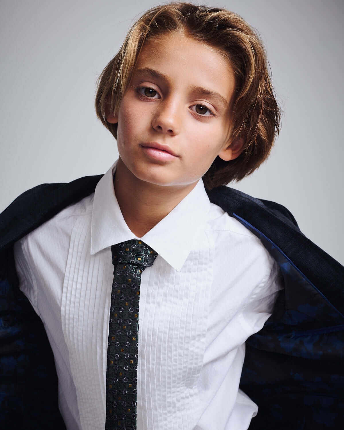 Young boy in formal attire wearing a Gold Spruce Tie, showcasing a stylish look for any occasion.