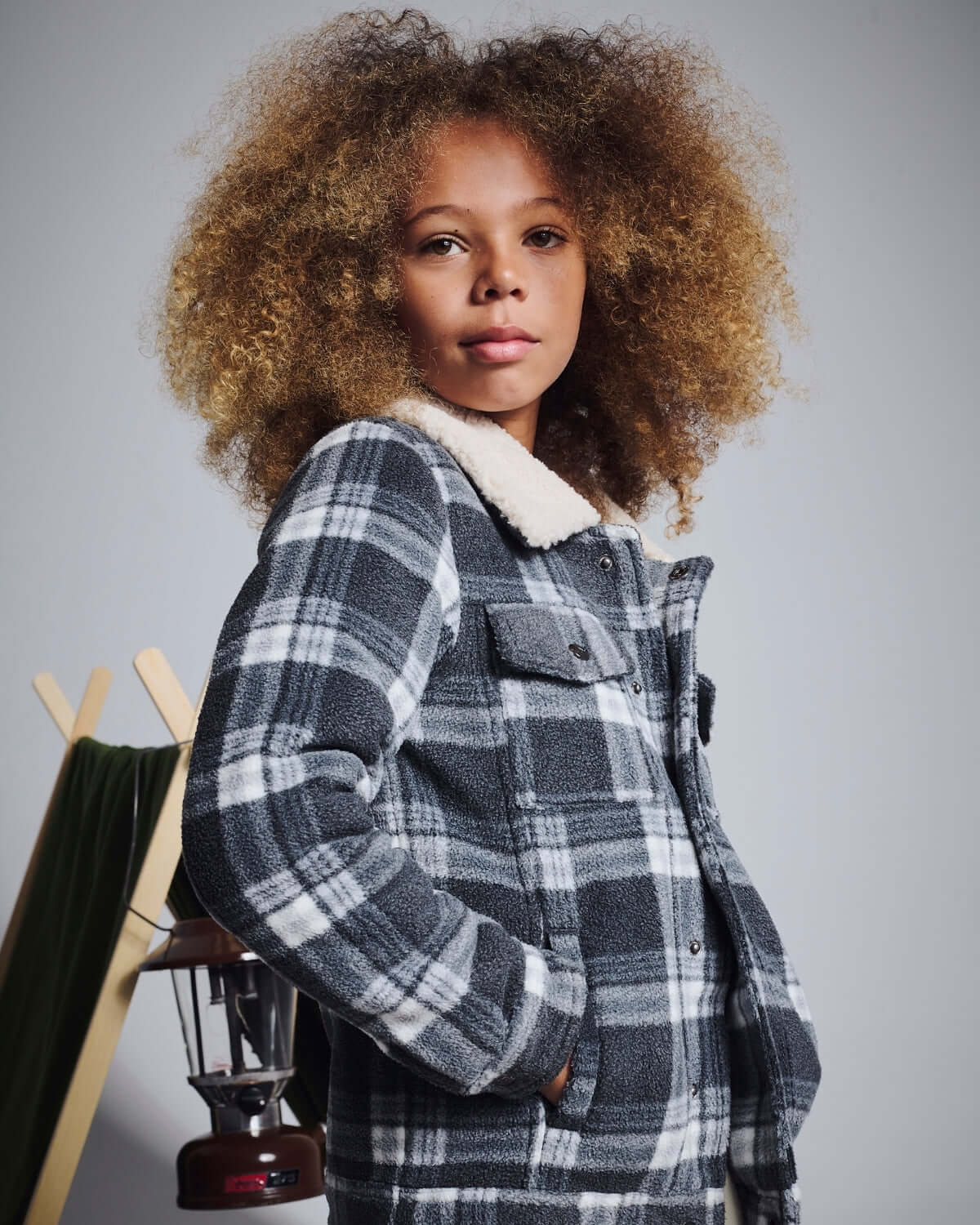 Child wearing a plaid jacket with a gray background