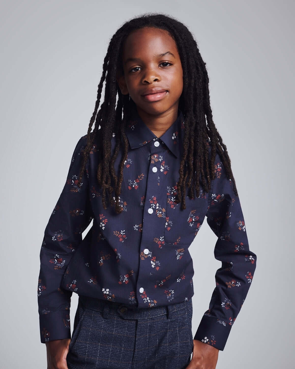 Kid wearing the Midnight Floral Standard Button Down shirt with a stylish floral design.