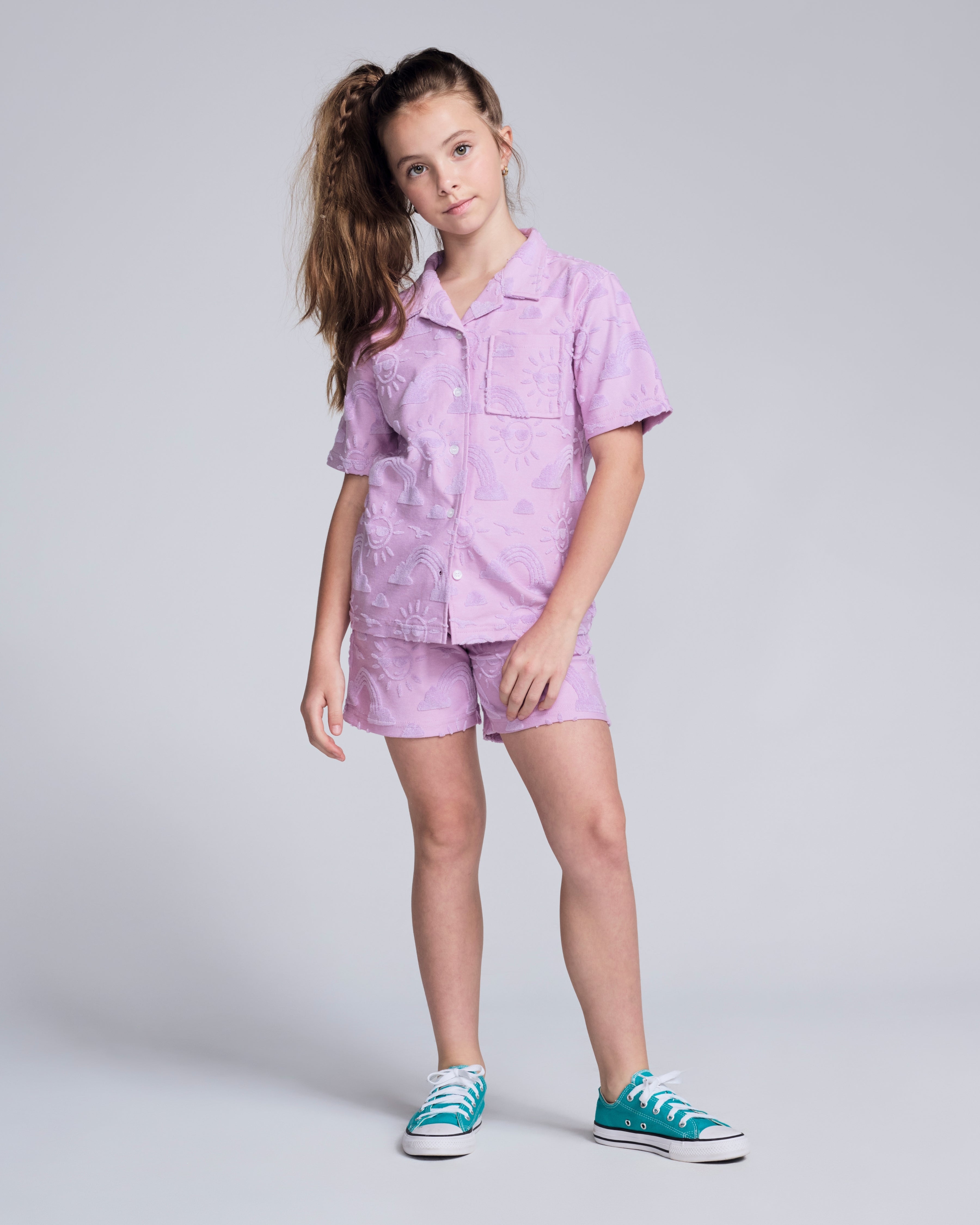 Girl wearing Sunny Days Terry Lilac Resort Short and matching shirt, perfect for summer fun and style.