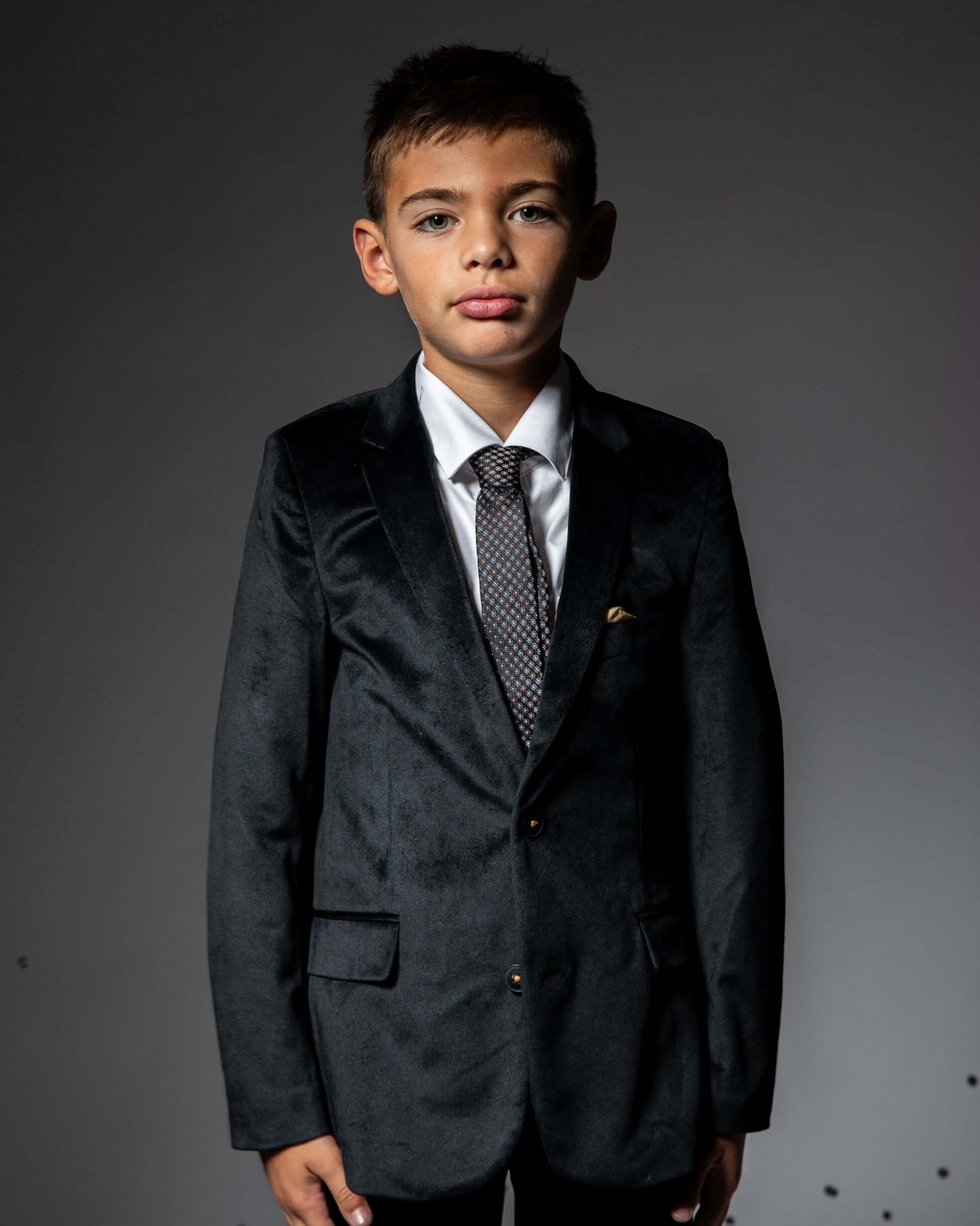 Boy wearing a Black Velvet Suit Blazer with a tie, perfect for special occasions and winter styling.