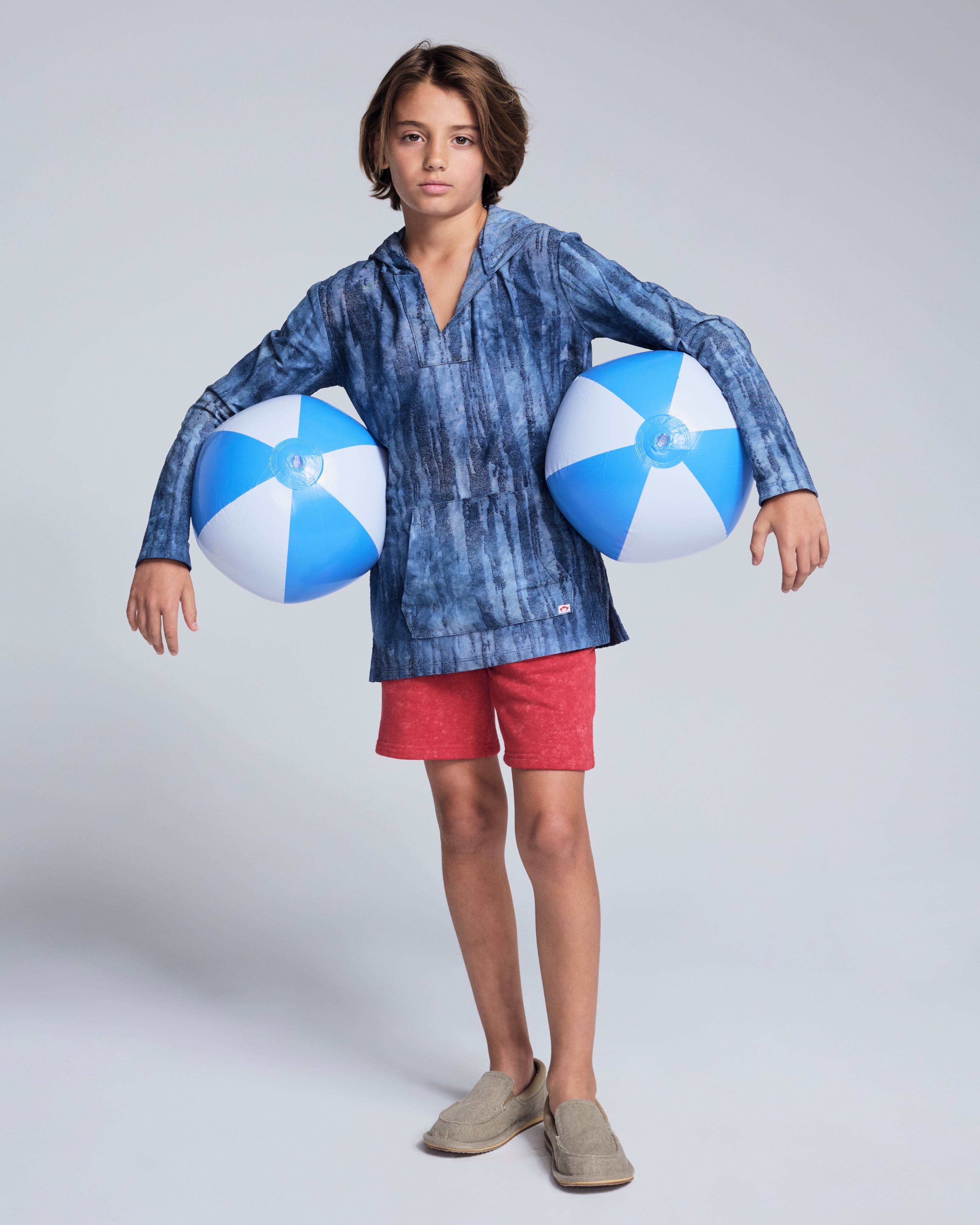 Boy wearing the Washed Red Preston Short and blue beach balls, ready for summer fun.