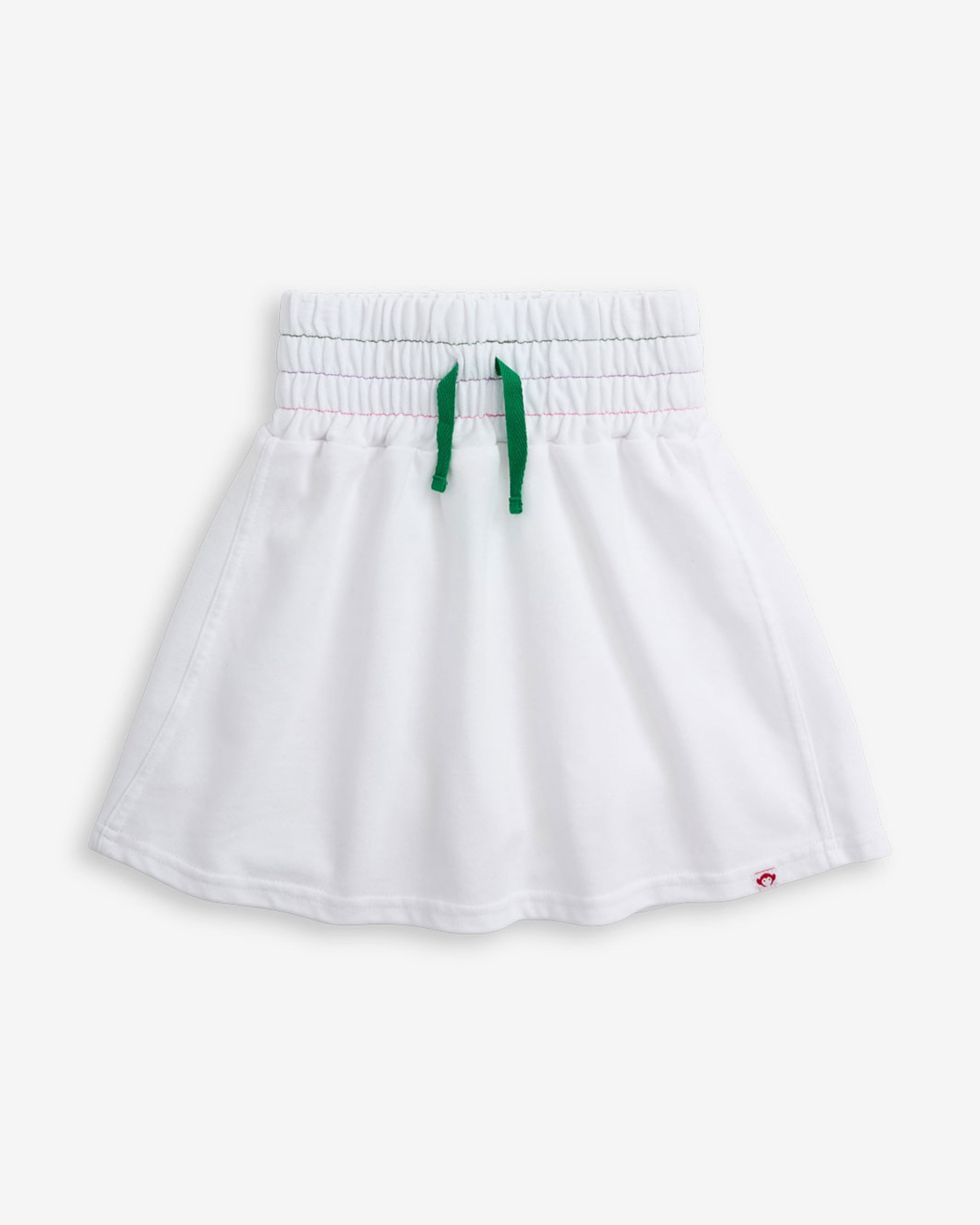 White Terry Laney Skort featuring a smocked waistband and green tie front detail.