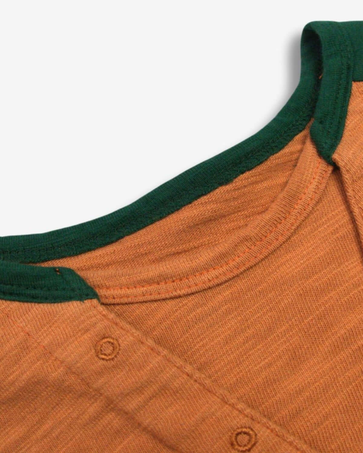 Close-up of the neckline of the Terracotta Baseball Tee, featuring a dark green collar and soft cotton fabric.