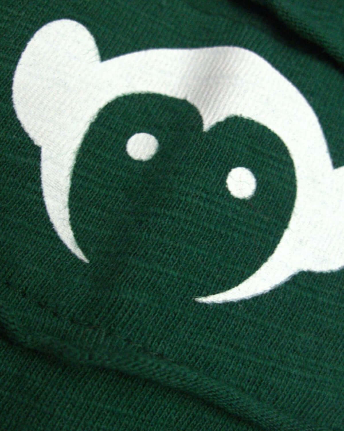 Close-up of green fabric with a playful monkey face design, ideal for casual wear alongside the Terracotta Baseball Tee.