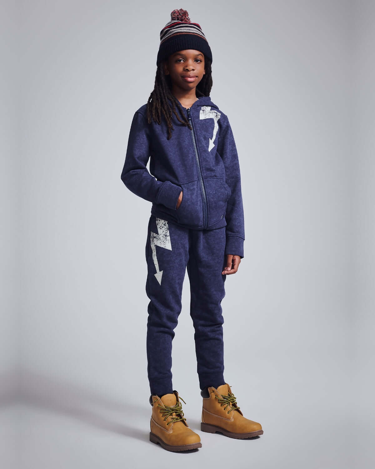 Washed Navy Bolt Sidewalk Sweatpants worn by a child, featuring a zip-up hoodie and a lightning bolt design.