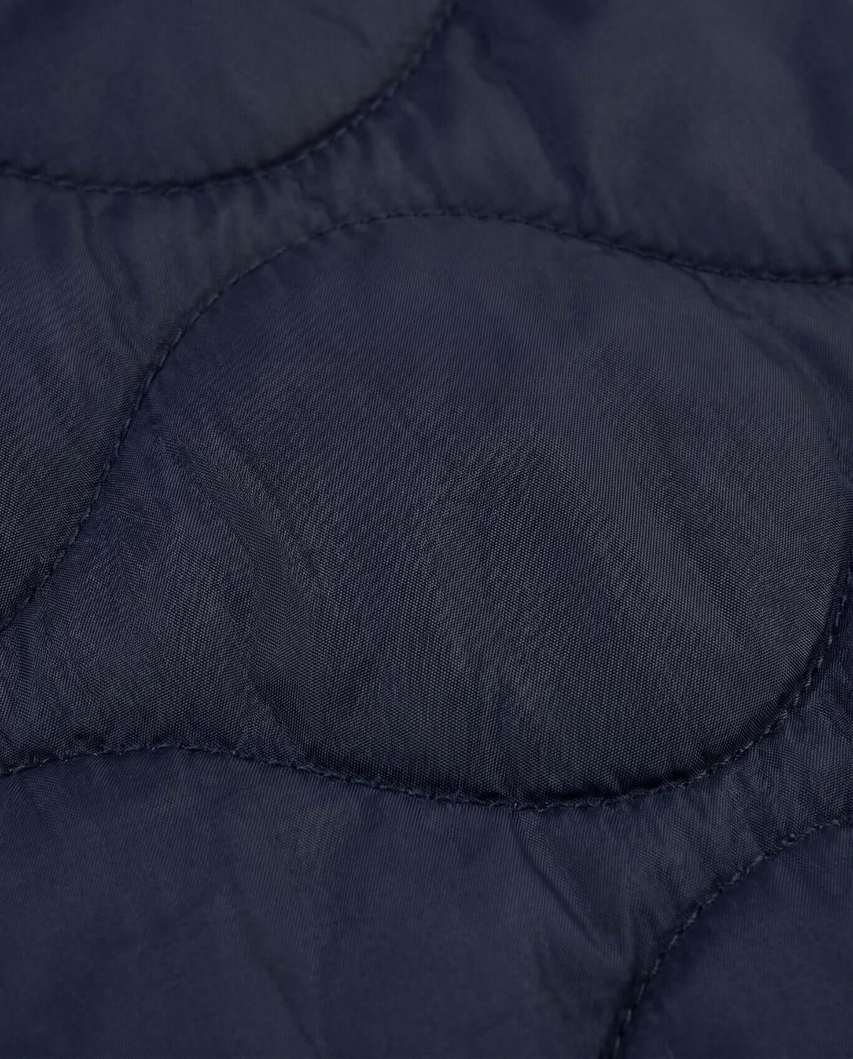 Close-up texture of the Black BX Bomber jacket showcasing its nylon fabric detail and quilted pattern.