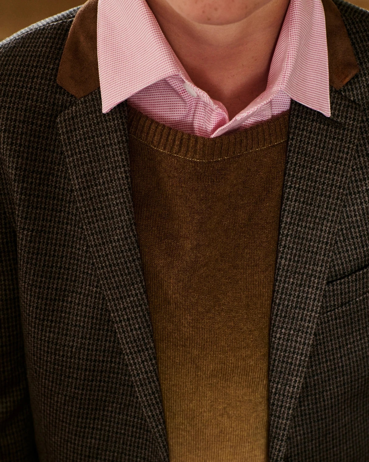 Close-up of a boy wearing a pink shirt under a brown cardigan. Appaman Fall/Winter 2026 collection.
