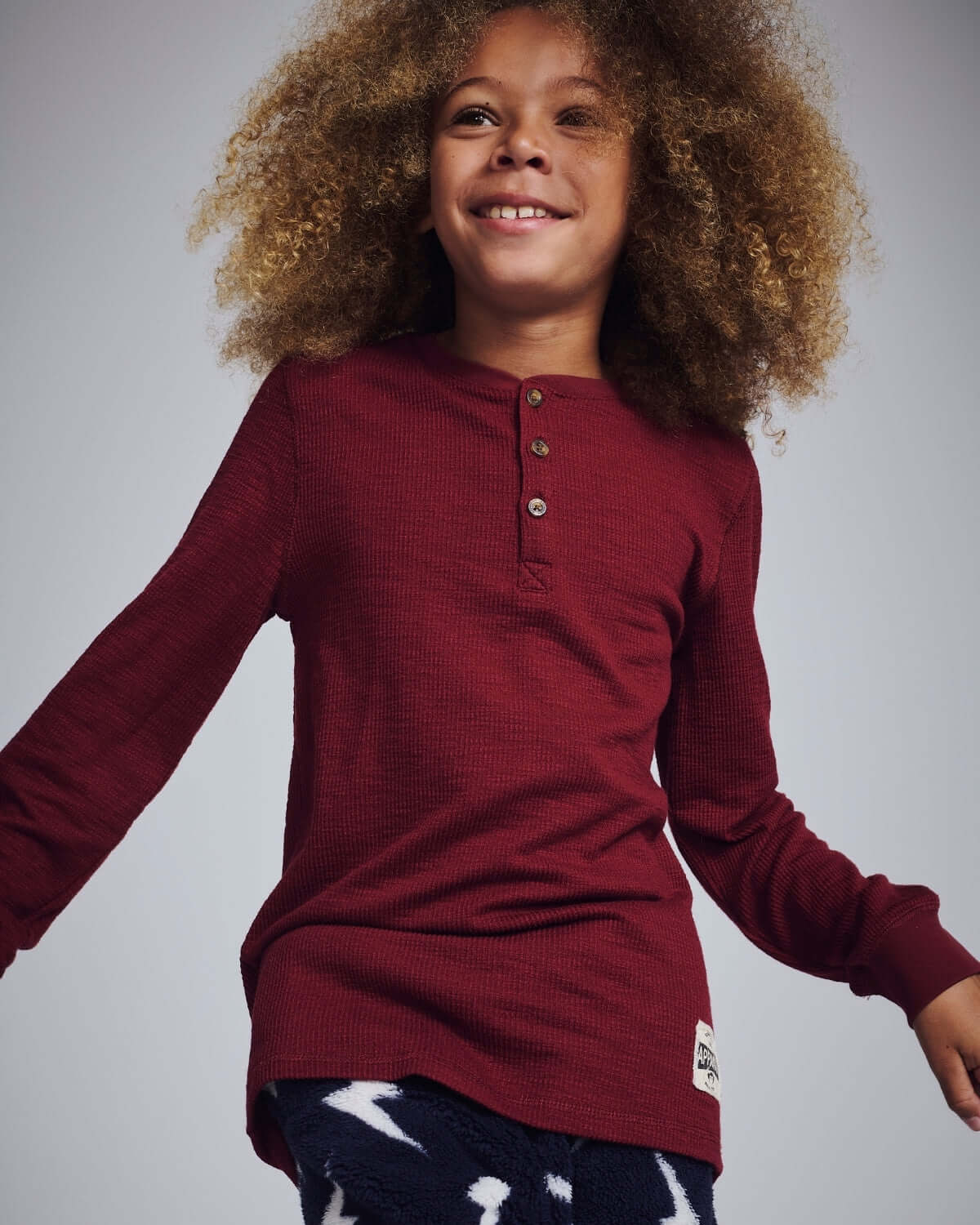 Dark Cherry Craftsman Thermal Henley worn by a smiling child with curly hair, displaying the cozy design.