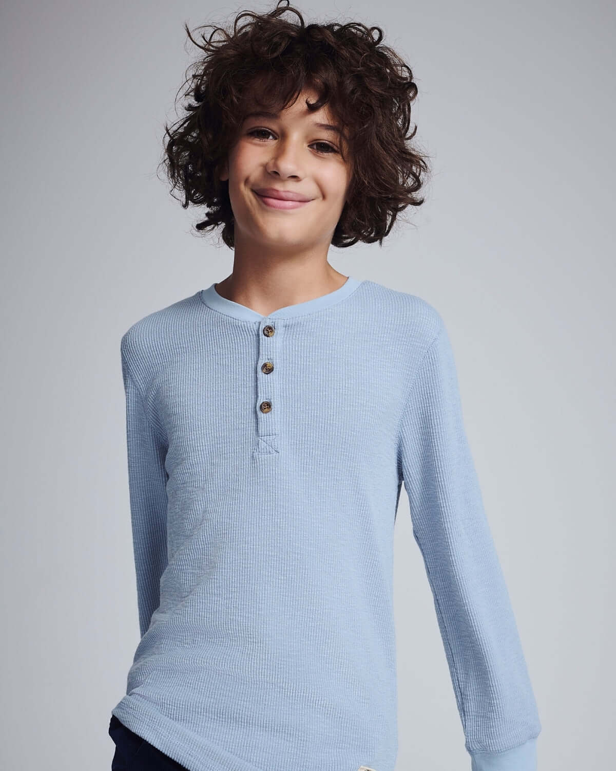 Dusty Blue Craftsman Thermal Henley displayed on a child with curly hair, showcasing its stylish design and soft fabric.