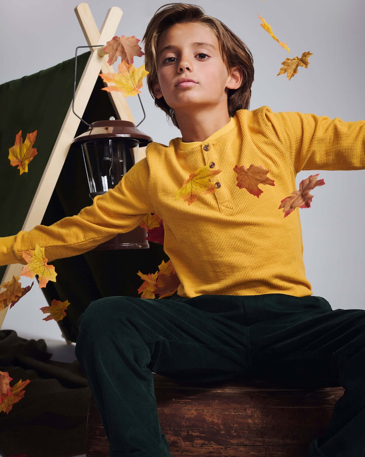 Mustard Craftsman Thermal Henley on a child surrounded by autumn leaves, showcasing style and comfort.