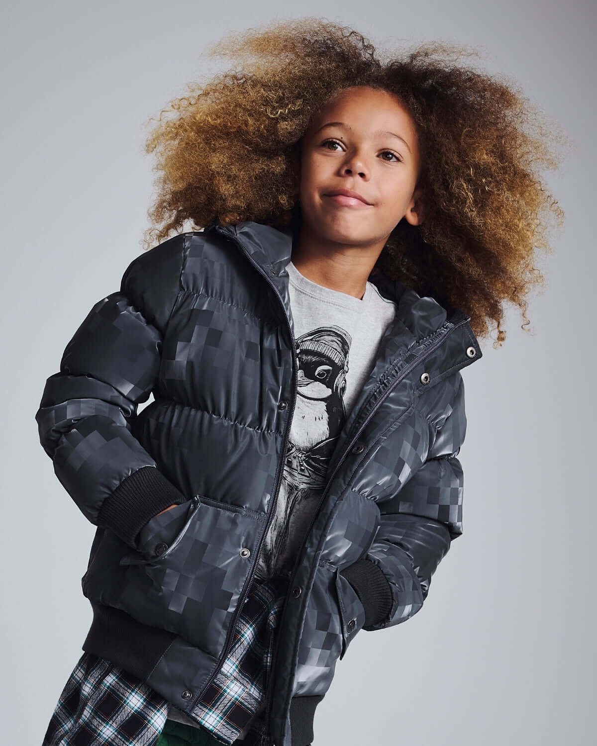 Child model wearing Digital Black Slim Puffy Coat with stylish hood and cozy pockets.