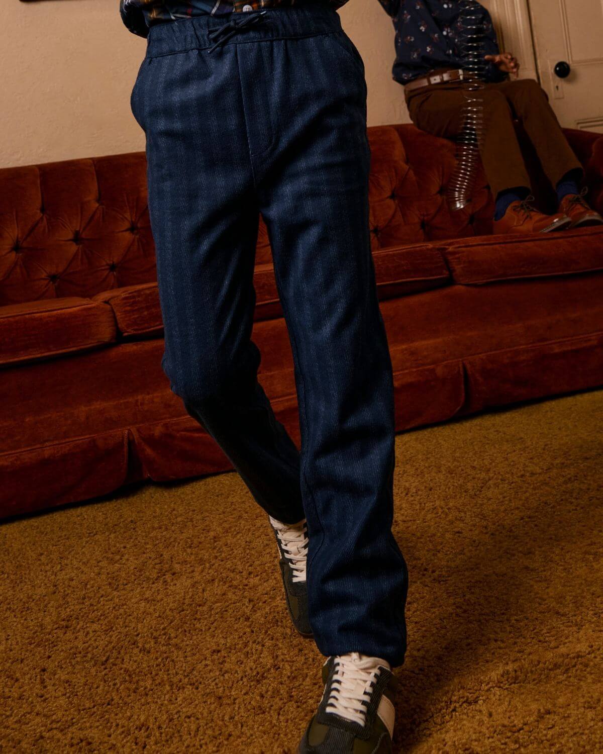 Navy Stripe Everyday Stretch Pants showcased on a model standing in cozy living room setting.
