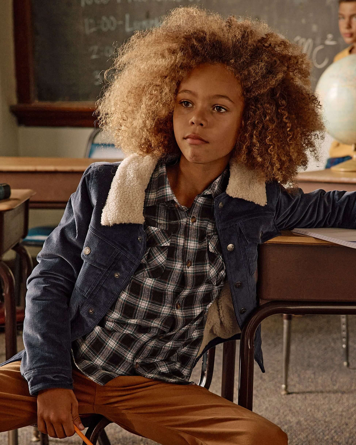 Child wearing a Black Umber Check Flannel Shirt with a denim jacket in a classroom setting.