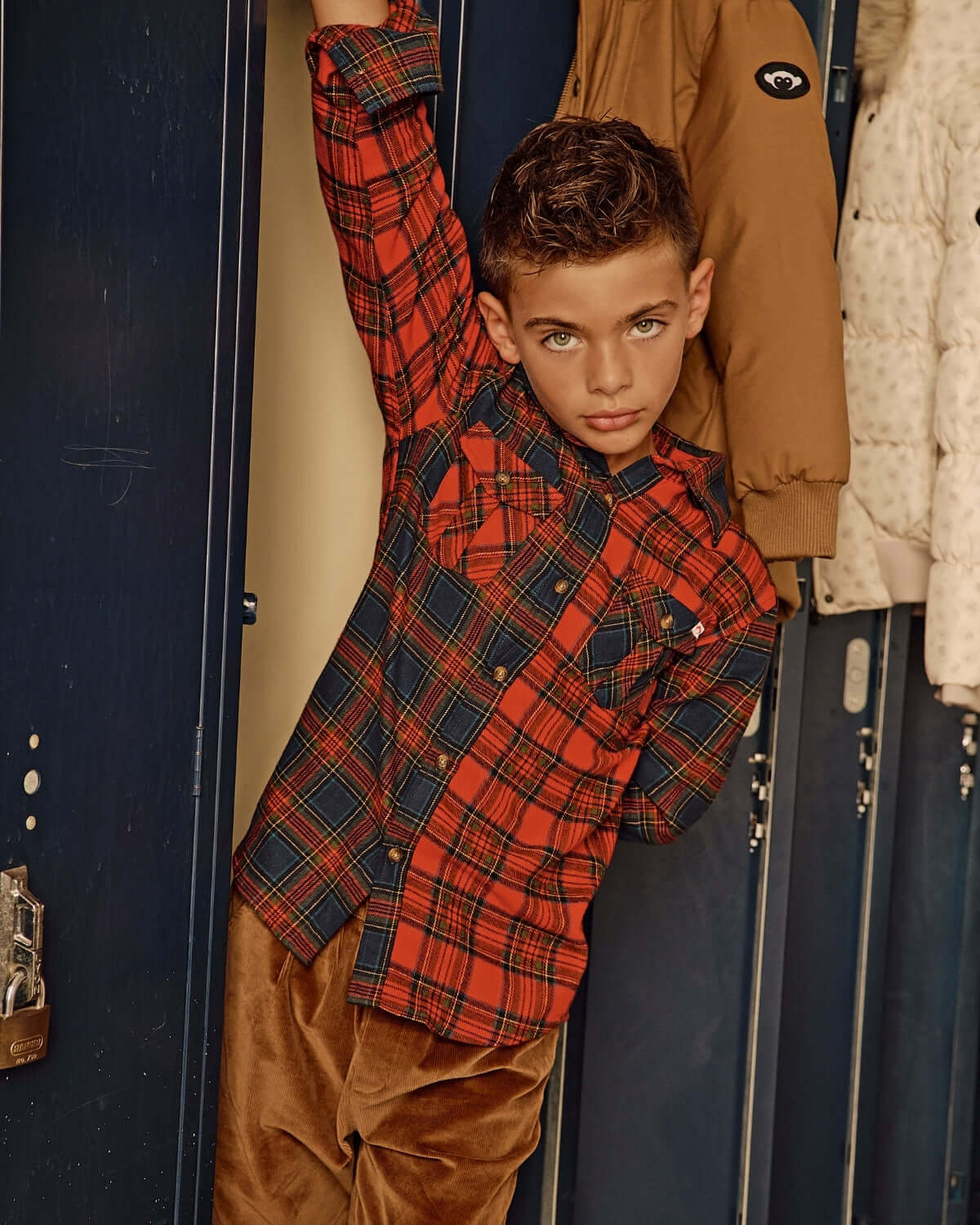 Holiday Plaid Flannel Shirt on a young boy posing in a school locker, showcasing its classic style and cozy feel.