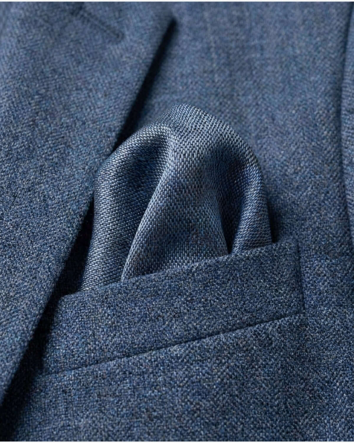 Close-up of blue textured fabric with a pocket detail