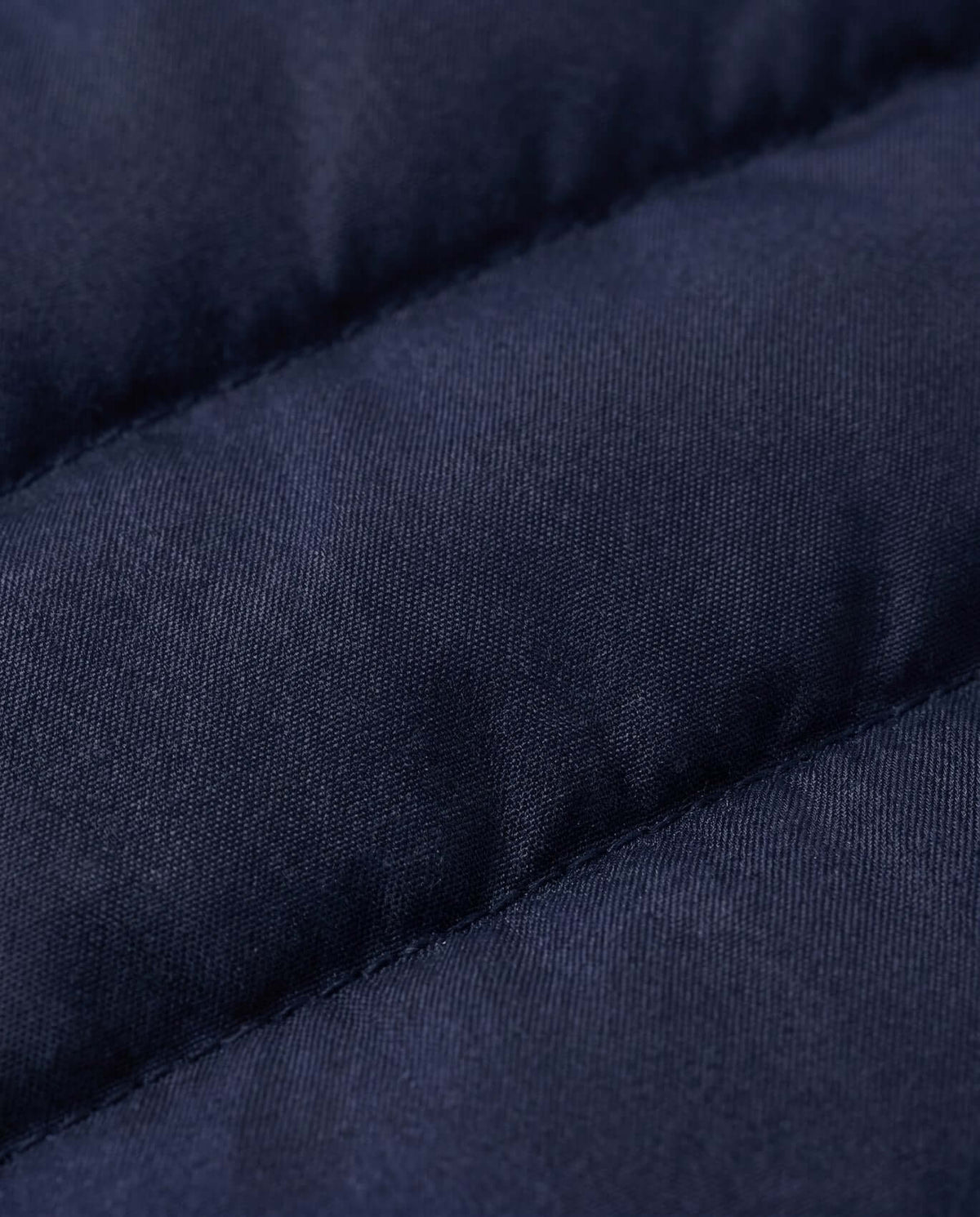 Close-up of the fabric texture of the Dark Navy Packable Lightweight Puffer jacket featuring quilted insulation.