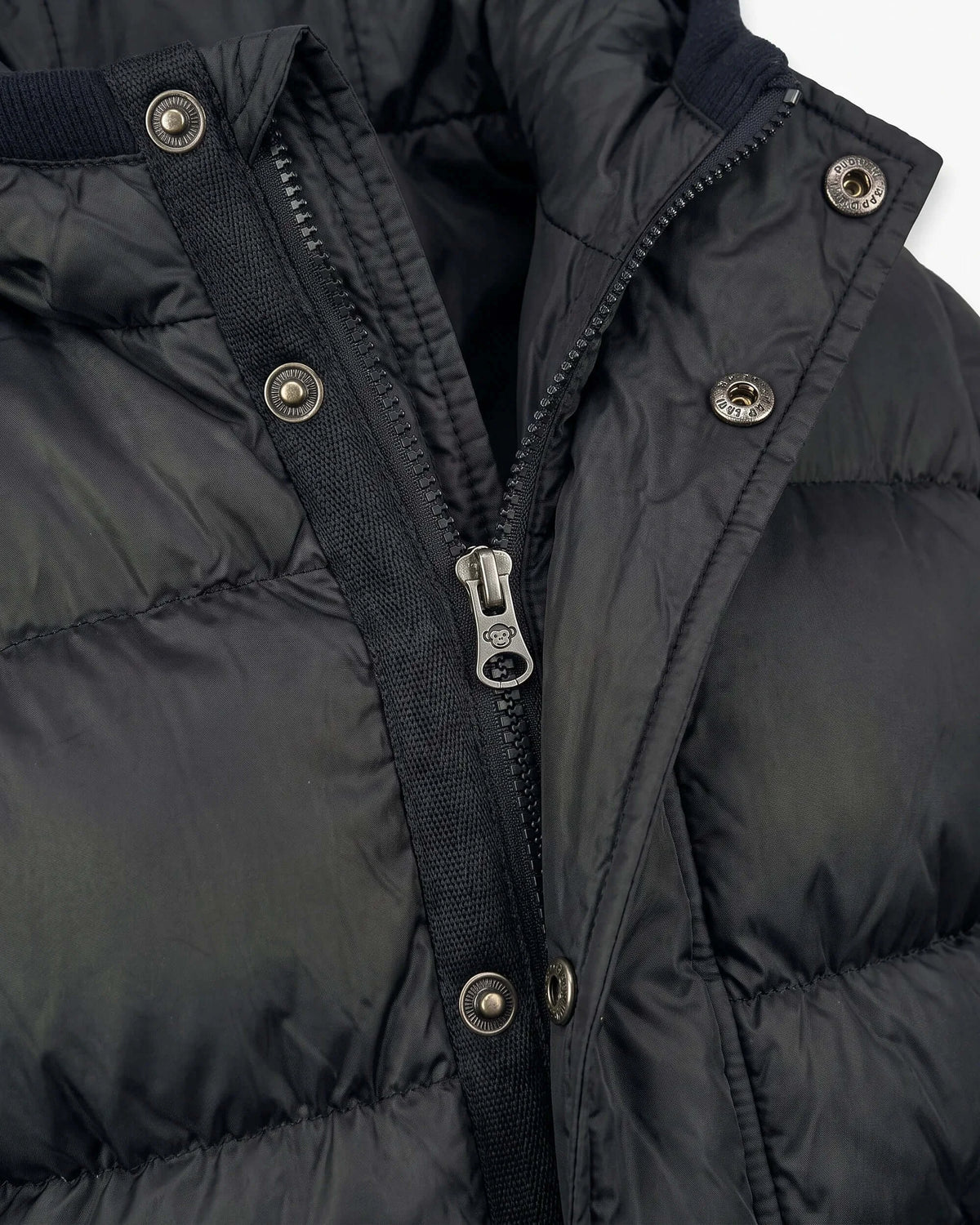 Close-up of the zipper and buttons on a Black Puffy Coat, showcasing its stylish and warm design.
