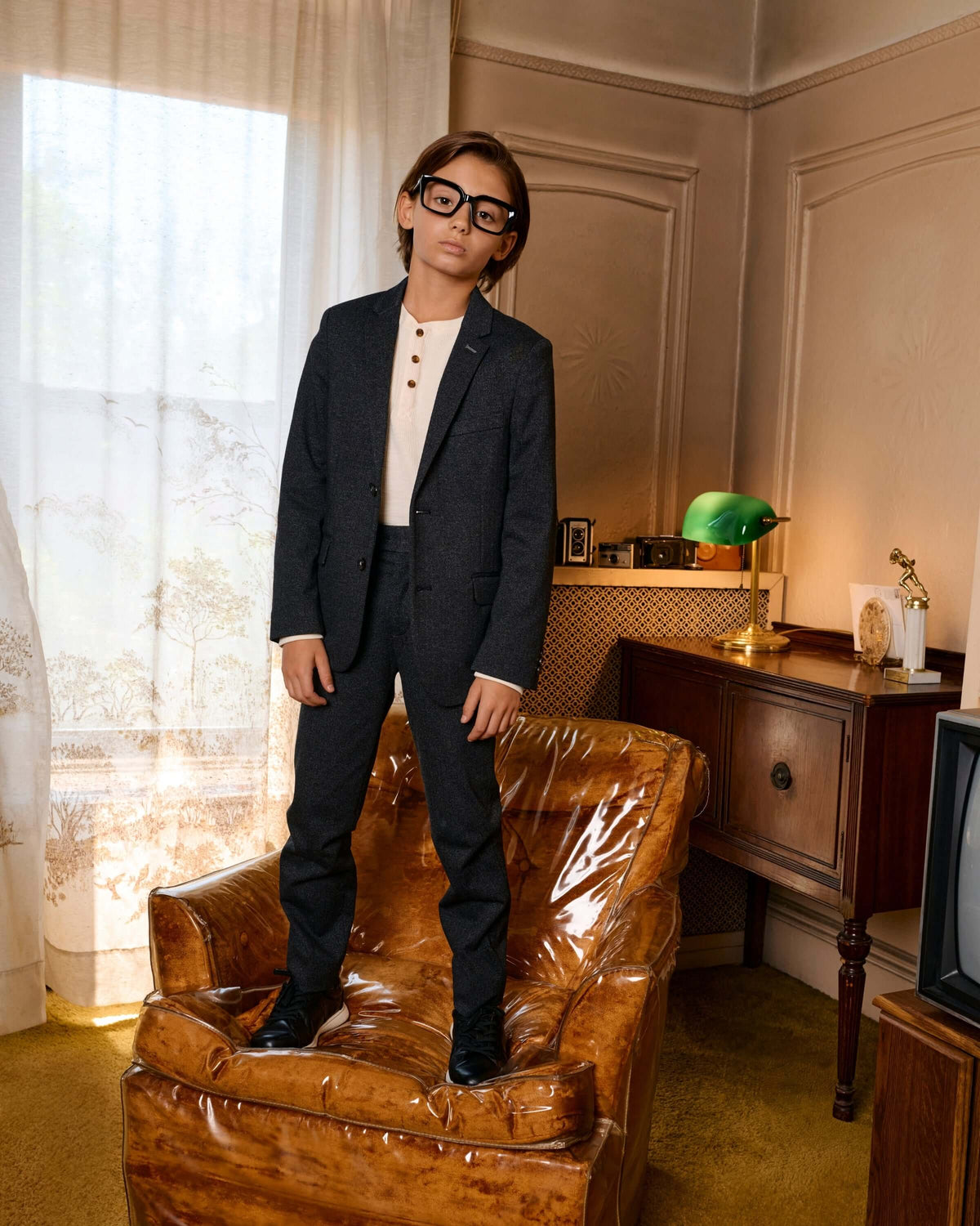 Black Herringbone Stretchy Suit Pants worn by a child in a stylish living room setting.
