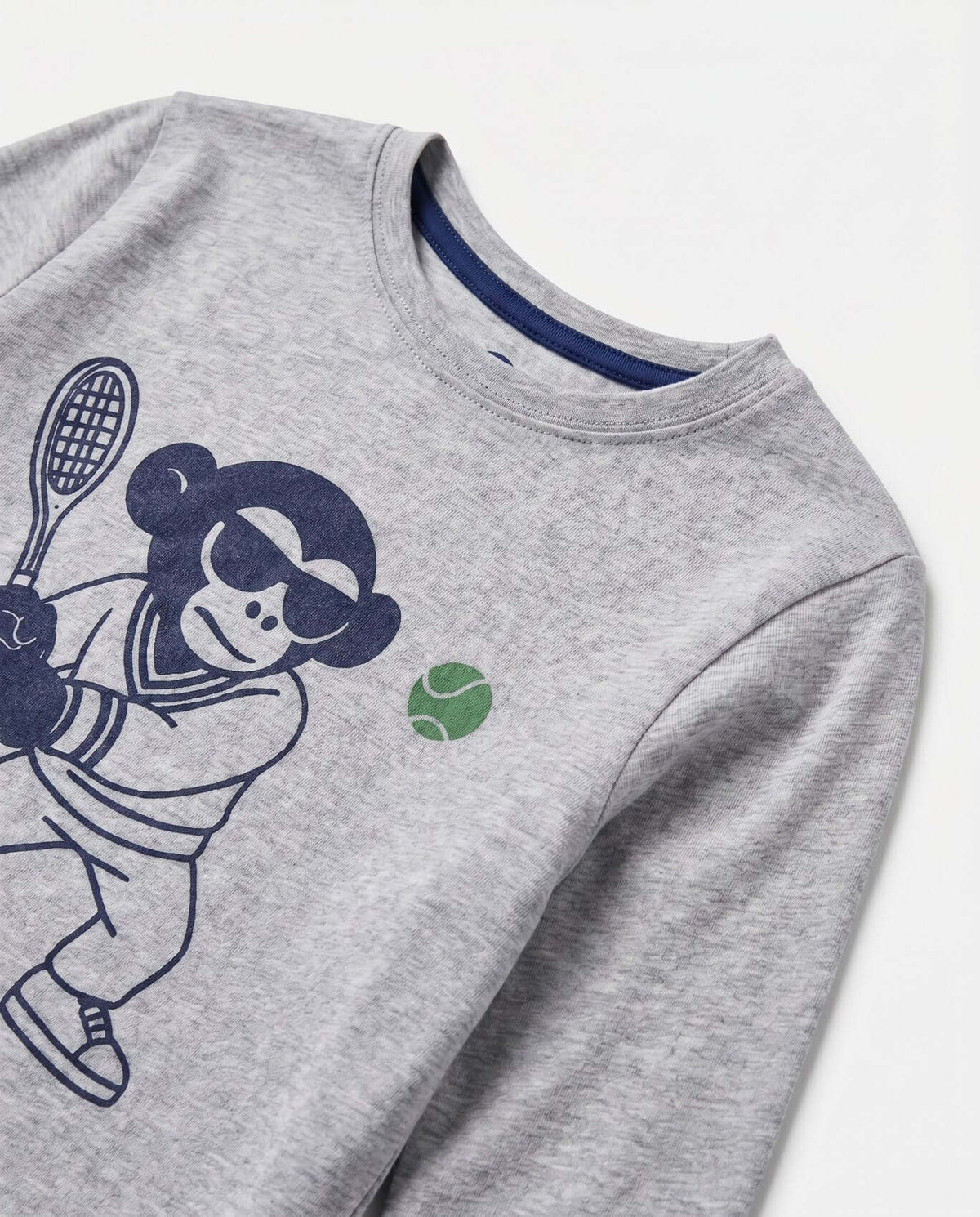 Tennis Pro Graphic Long Sleeve Tee featuring a playful monkey graphic and tennis ball on a heather mist background.