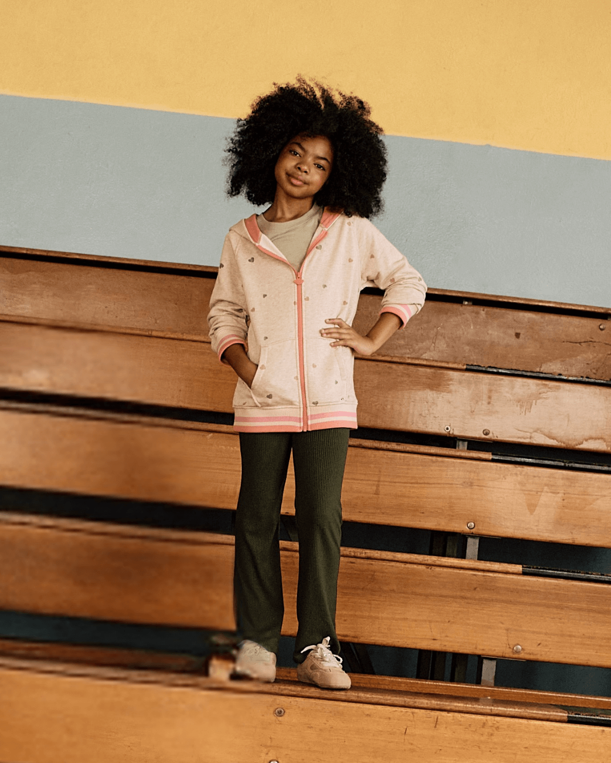 A child wearing Olive Flare Leggings paired with a stylish hoodie, showcasing comfort and playful fashion.