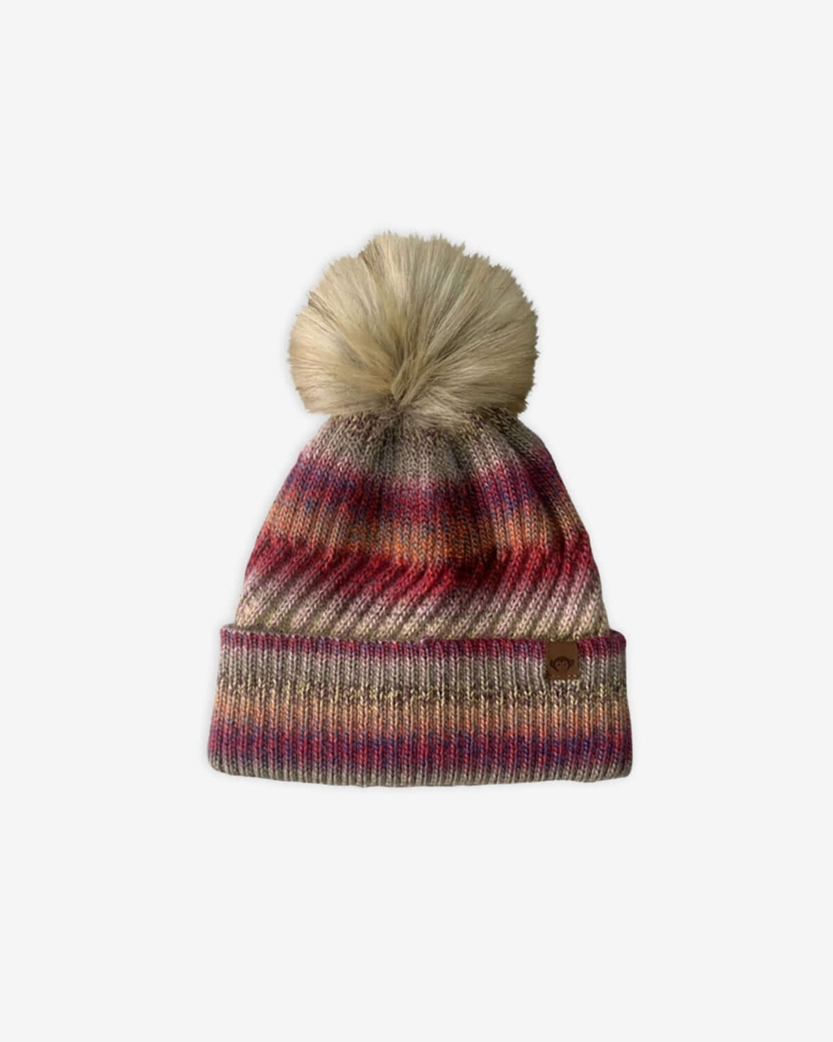 Rose Iris Pom Beanie in pink, red, and beige tones with a fluffy pom pom on top.
