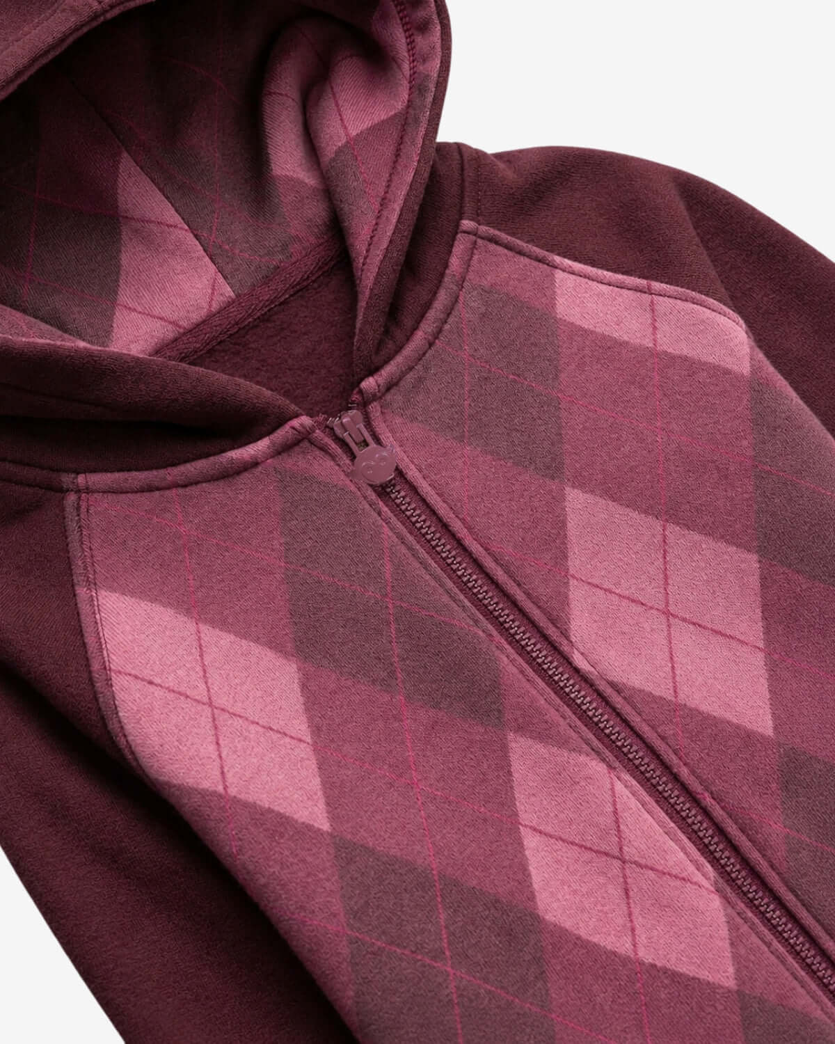 Close-up of a maroon and gray checkered hoodie with a zipper.