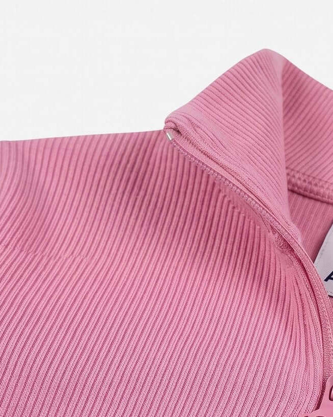 Close-up of a pink ribbed fabric with a brand label.