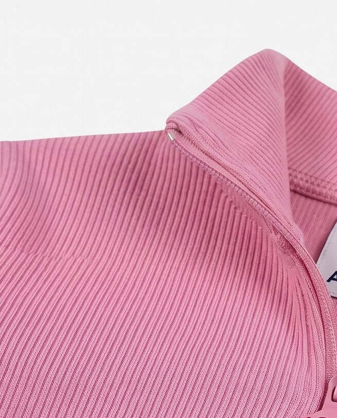 Close-up of a pink ribbed fabric with a brand label.