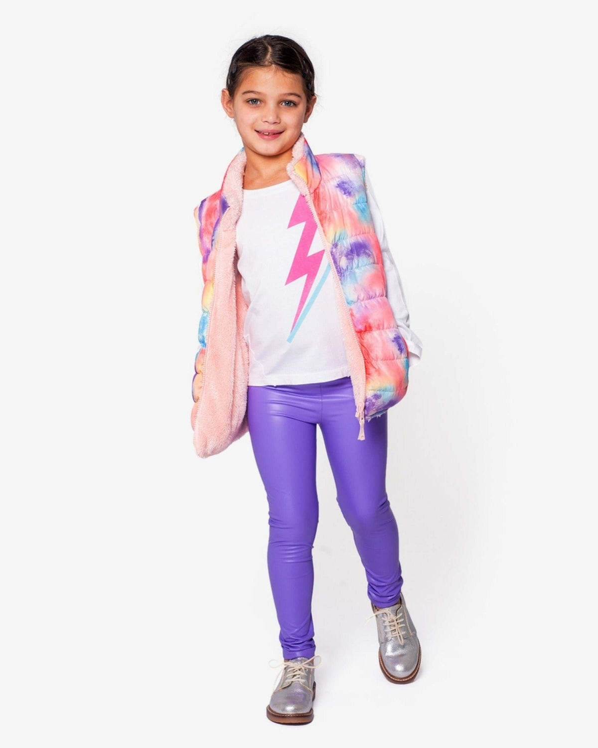 A young girl wearing the Lightning Bolt Adler Tee, styled with a colorful vest and purple leggings.