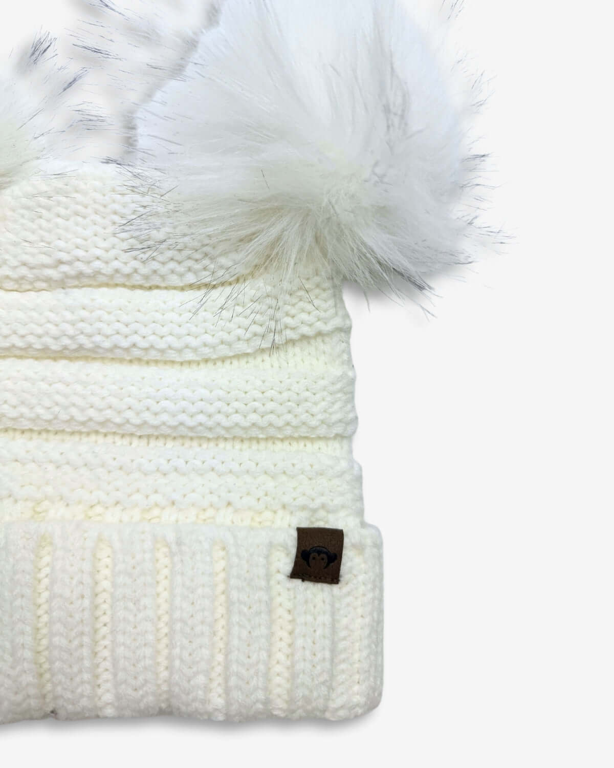 Winter White Mia Pom-Pom Beanie with faux fur pom poms and cream ribbed knitting for stylish warmth.